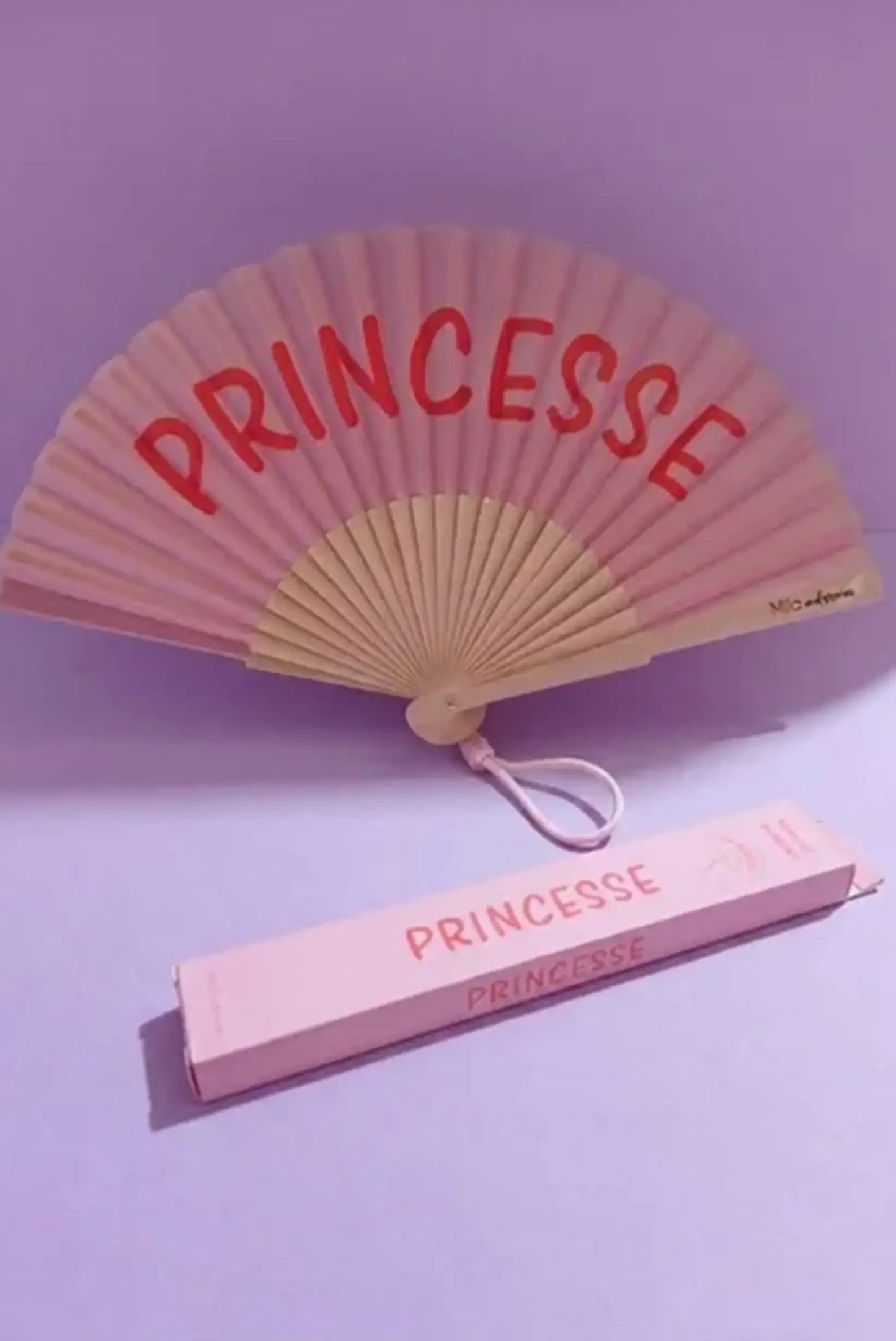 Abanico rosa con texto 'PRINCESSE' y caja a juego, ideal como complemento de moda femenina.