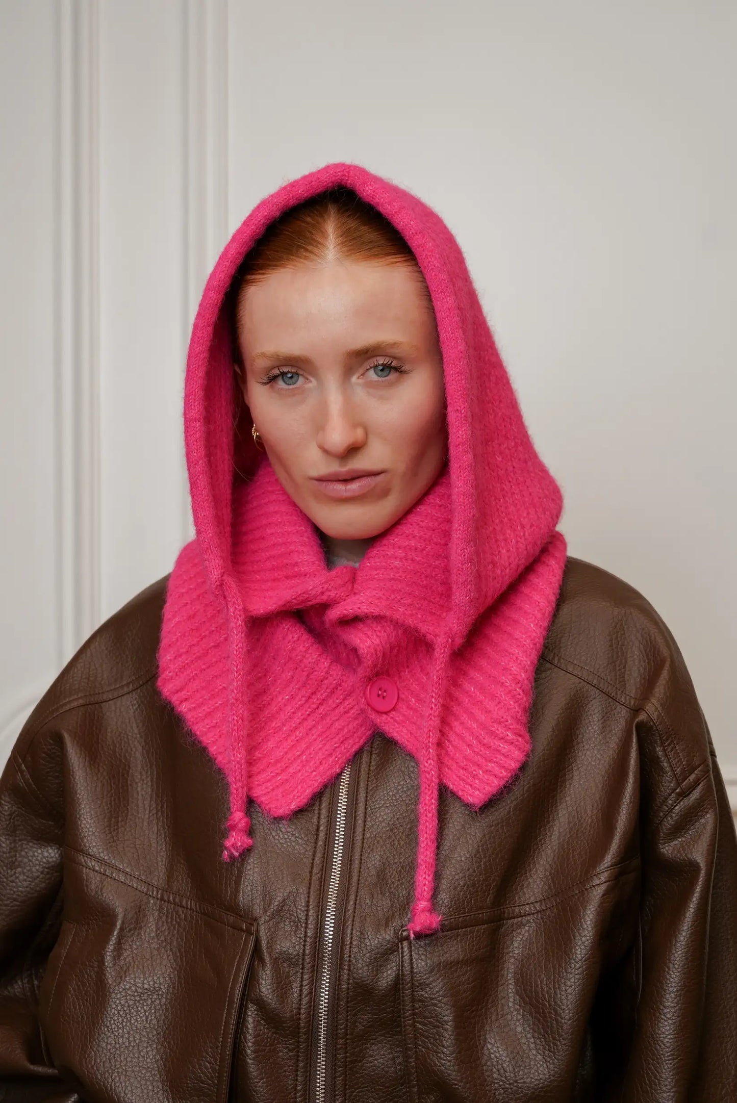 Mujer con balaclava fucsia de punto y chaqueta marrón, moda invierno CHICA del Sur.