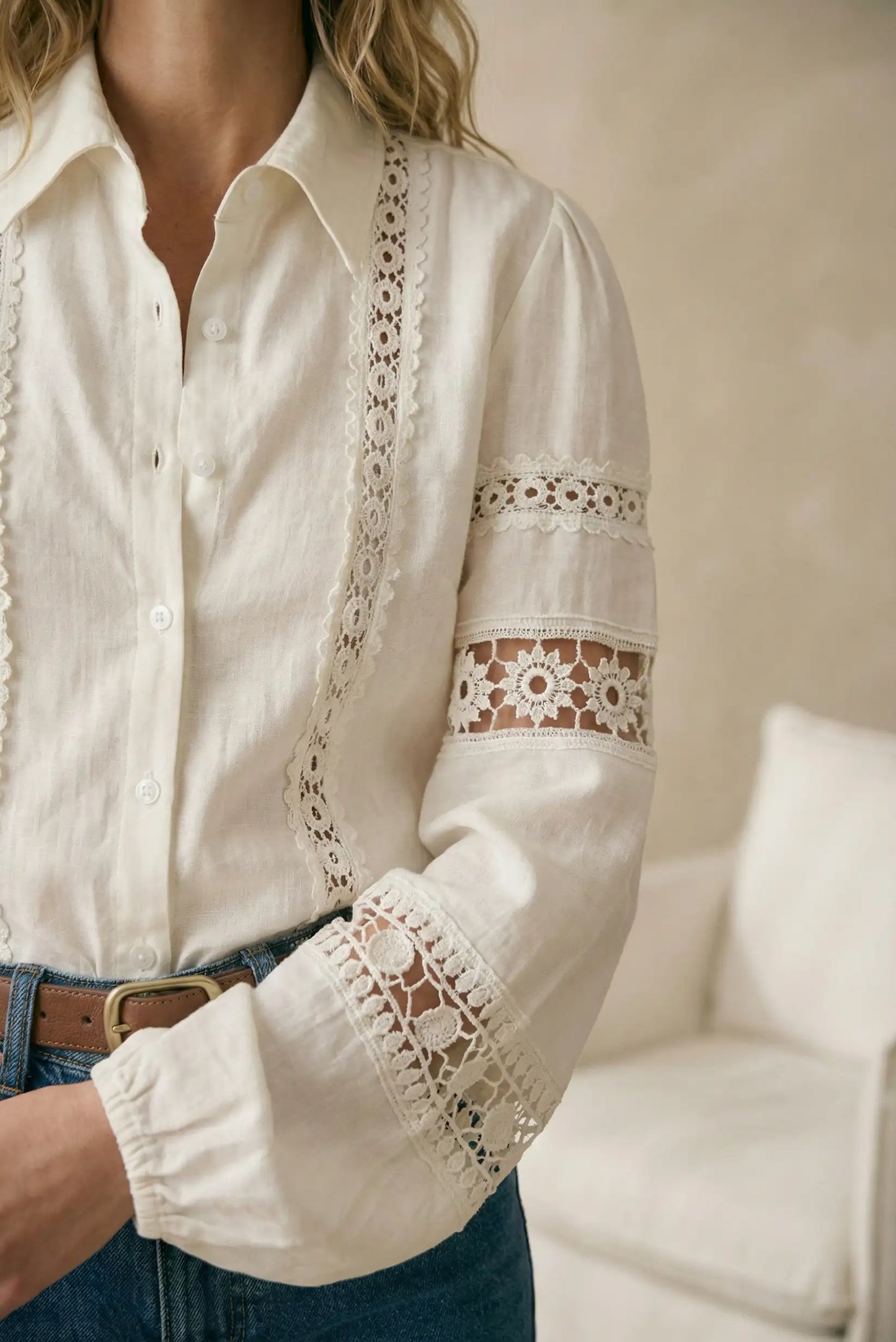 Blusa blanca de mujer con manga larga, encaje floral y botón, estilo casual primavera.