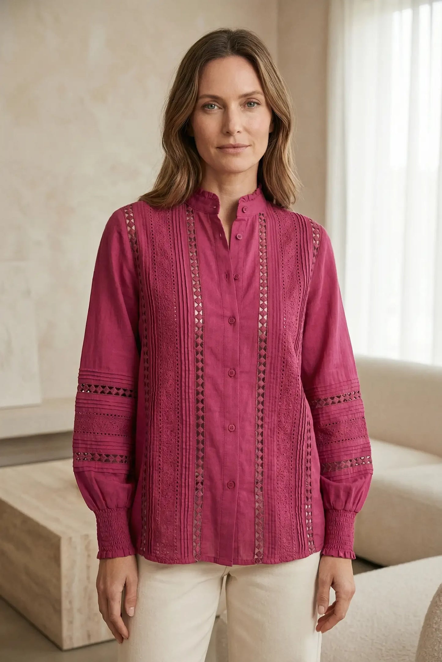Mujer con blusa de manga larga color cereza y detalles bordados, moda primavera casual.