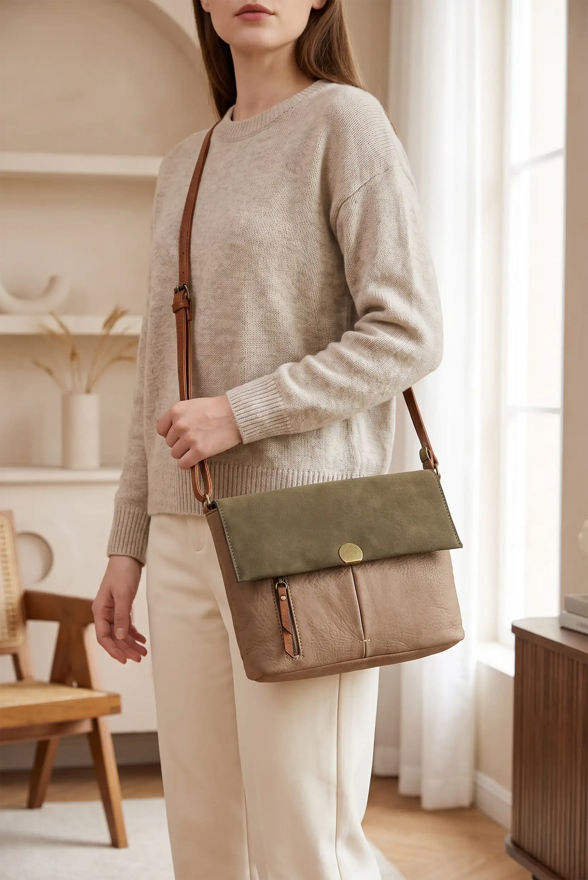 Mujer con jersey beige y bolso bandolera de cuero en tonos marrón y verde oliva