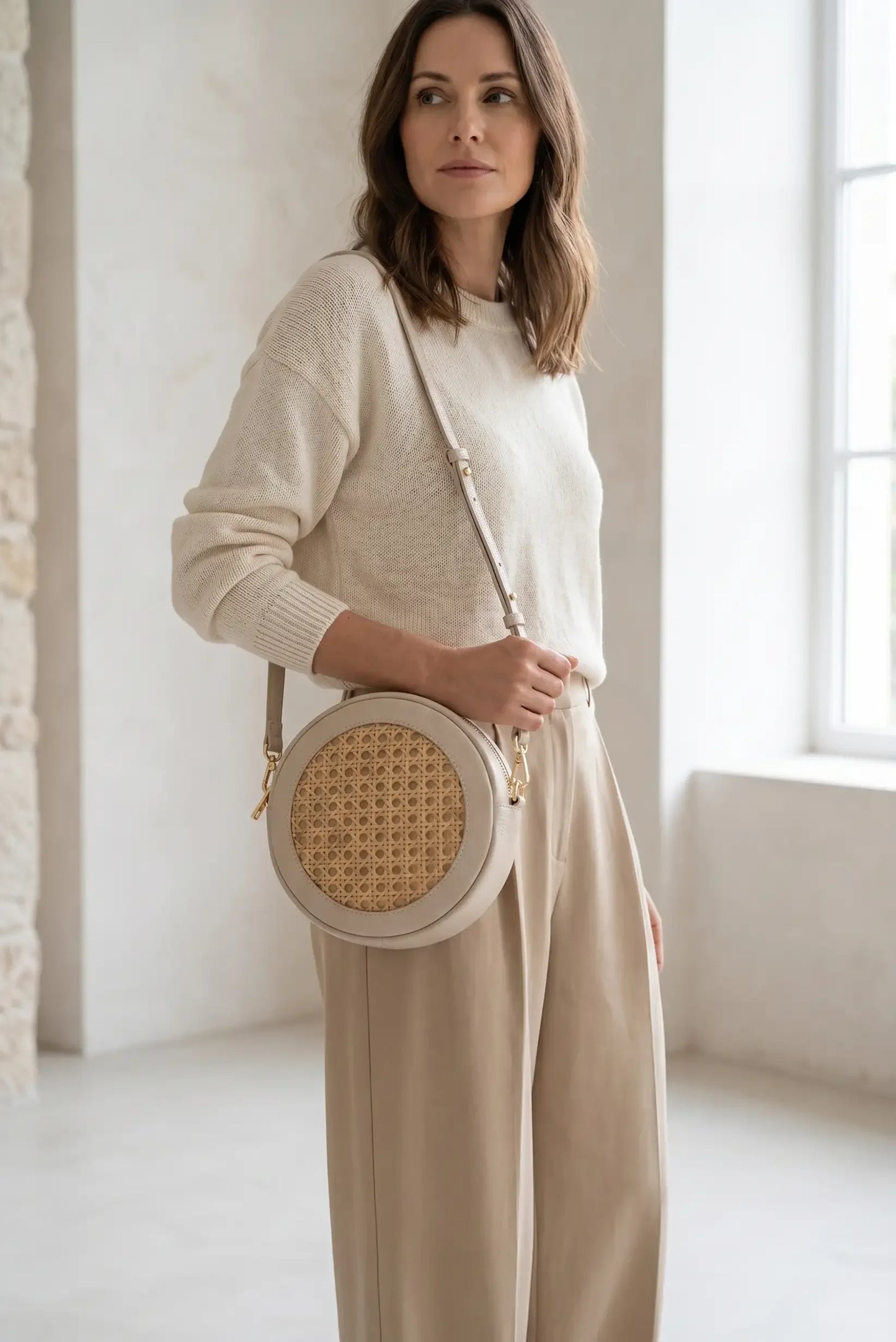 Bolso redondo de mimbre con detalles en beige, ideal para looks casuales y estilosos