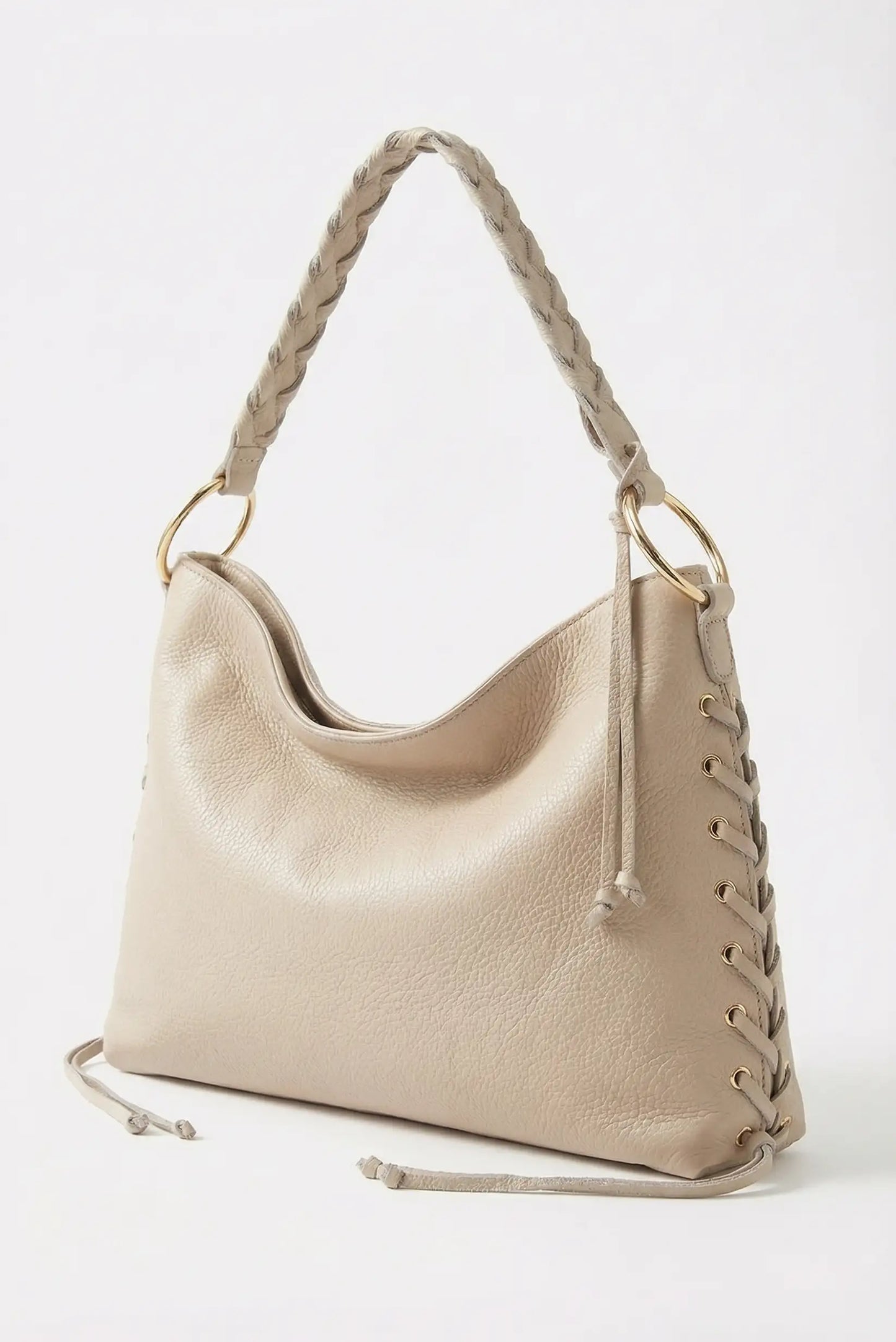 Bolso de mano mediano para mujer en color beige, asa trenzada y detalle de ojales dorados.