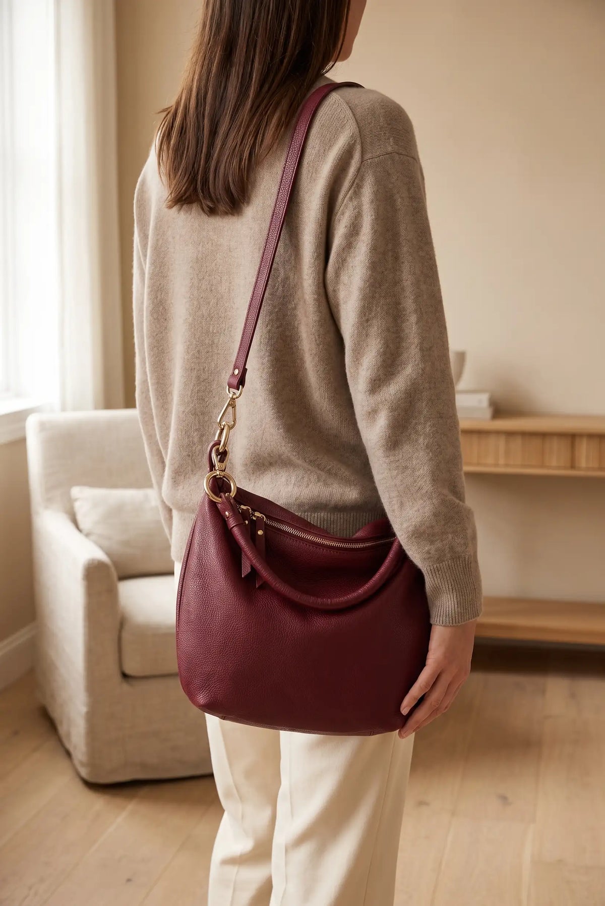 Mujer con jersey beige y bolso bandolera de cuero color granate
