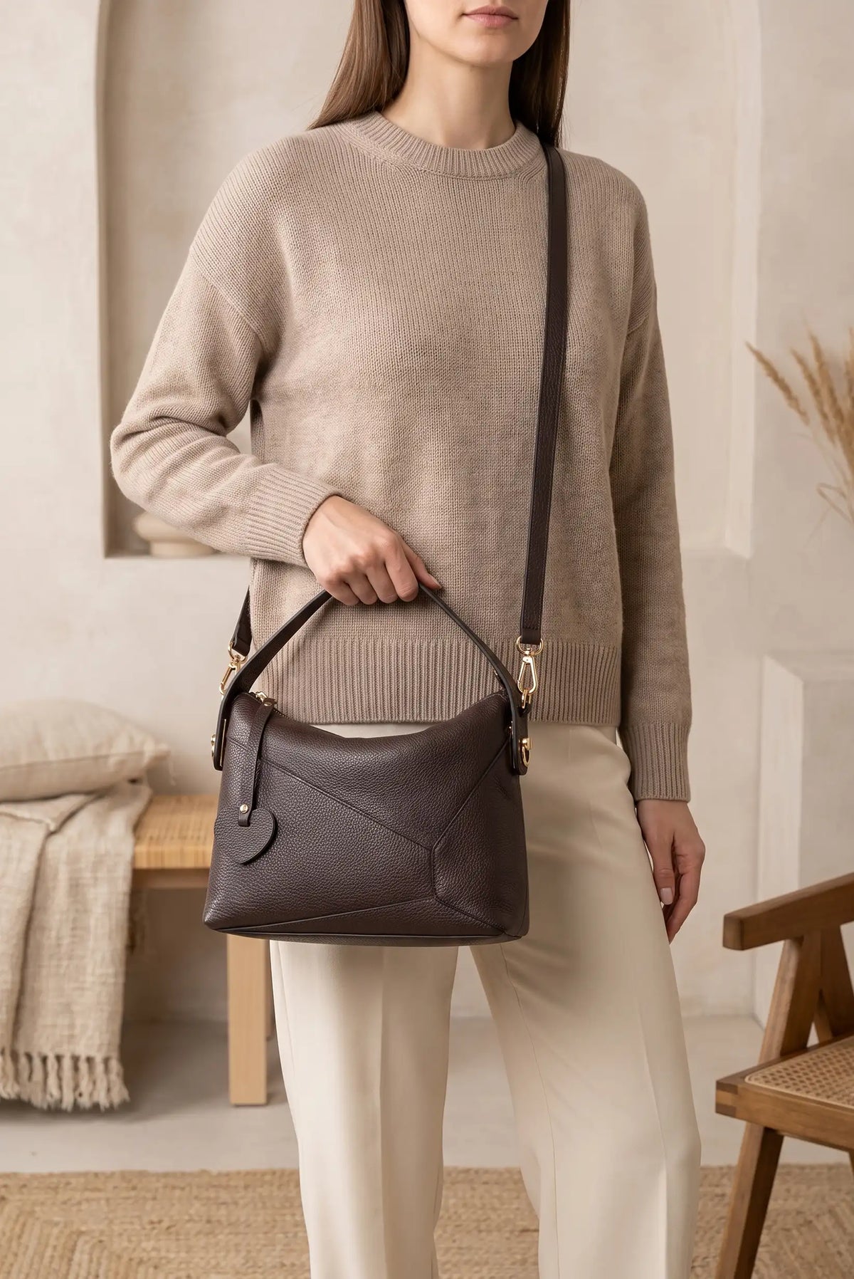 Mujer vistiendo jersey beige y pantalón blanco con bolso Puzzle de piel marrón de CHICA del Sur