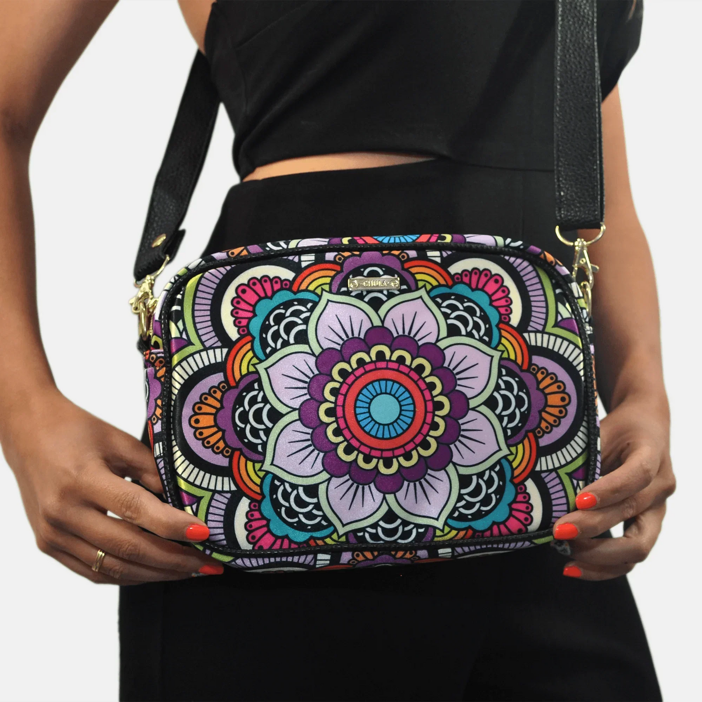 Bolso pequeño de mano y bandolera con mandala colorido arcoíris, fondo blanco.