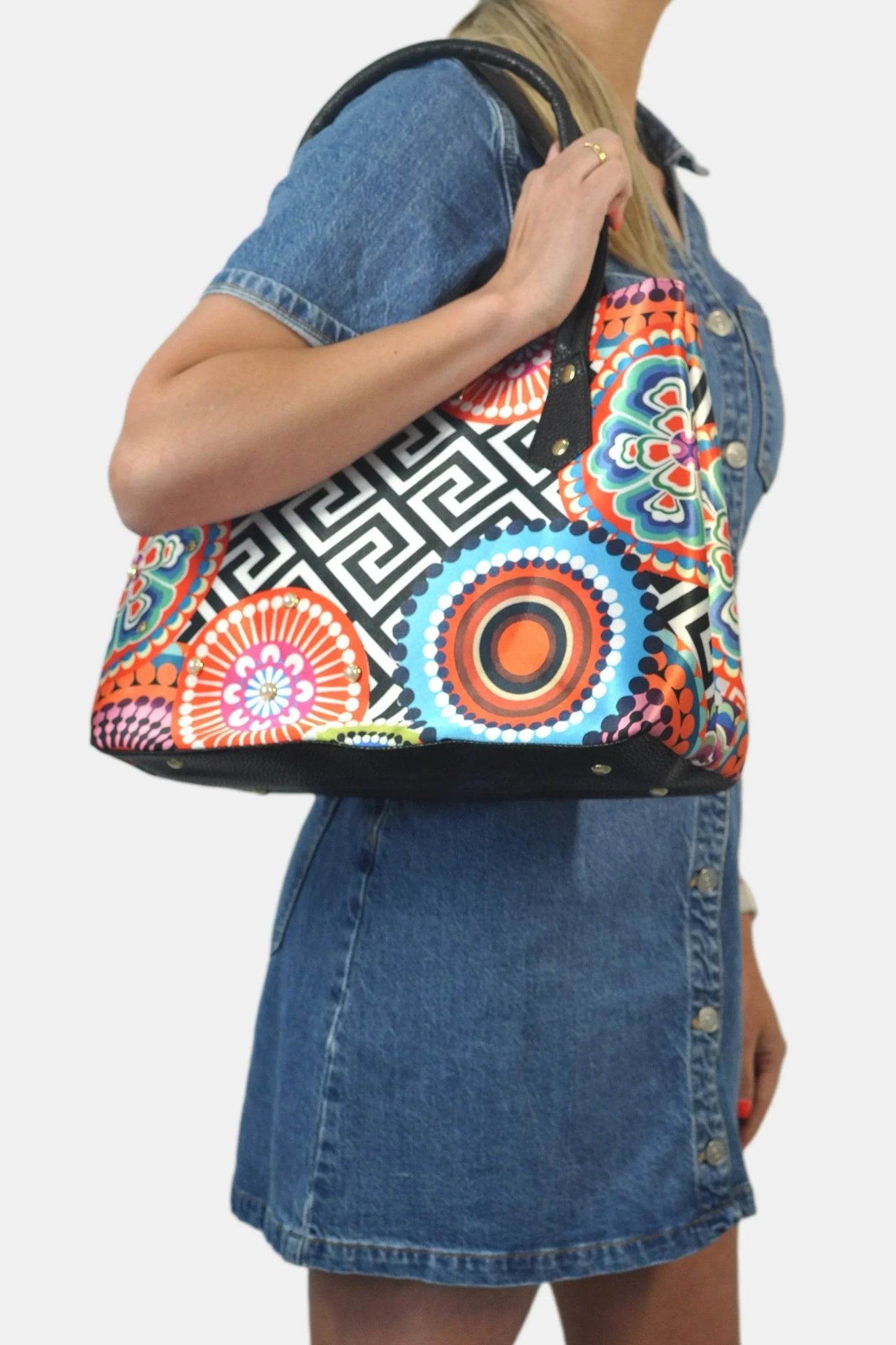 Bolso shopper tote grande estampado círculos coloridos, asa negra, modelo con vestido de mezclilla.