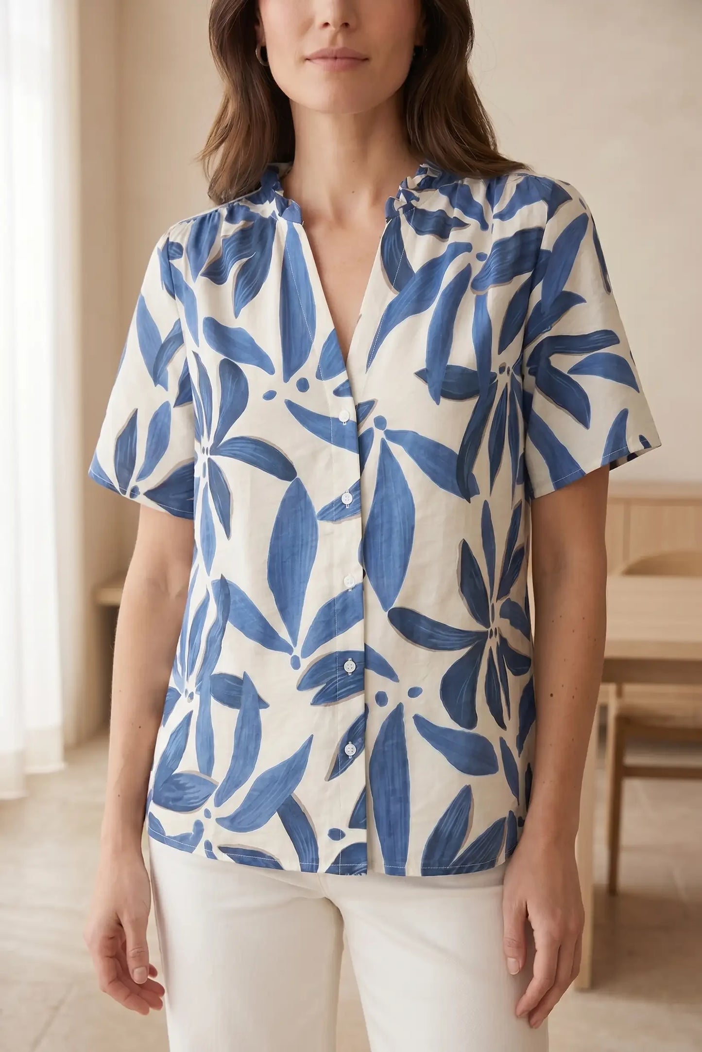 Blusa casual con estampado floral azul y blanco, manga corta y cuello botones, ideal para looks estilosos y cómodos.