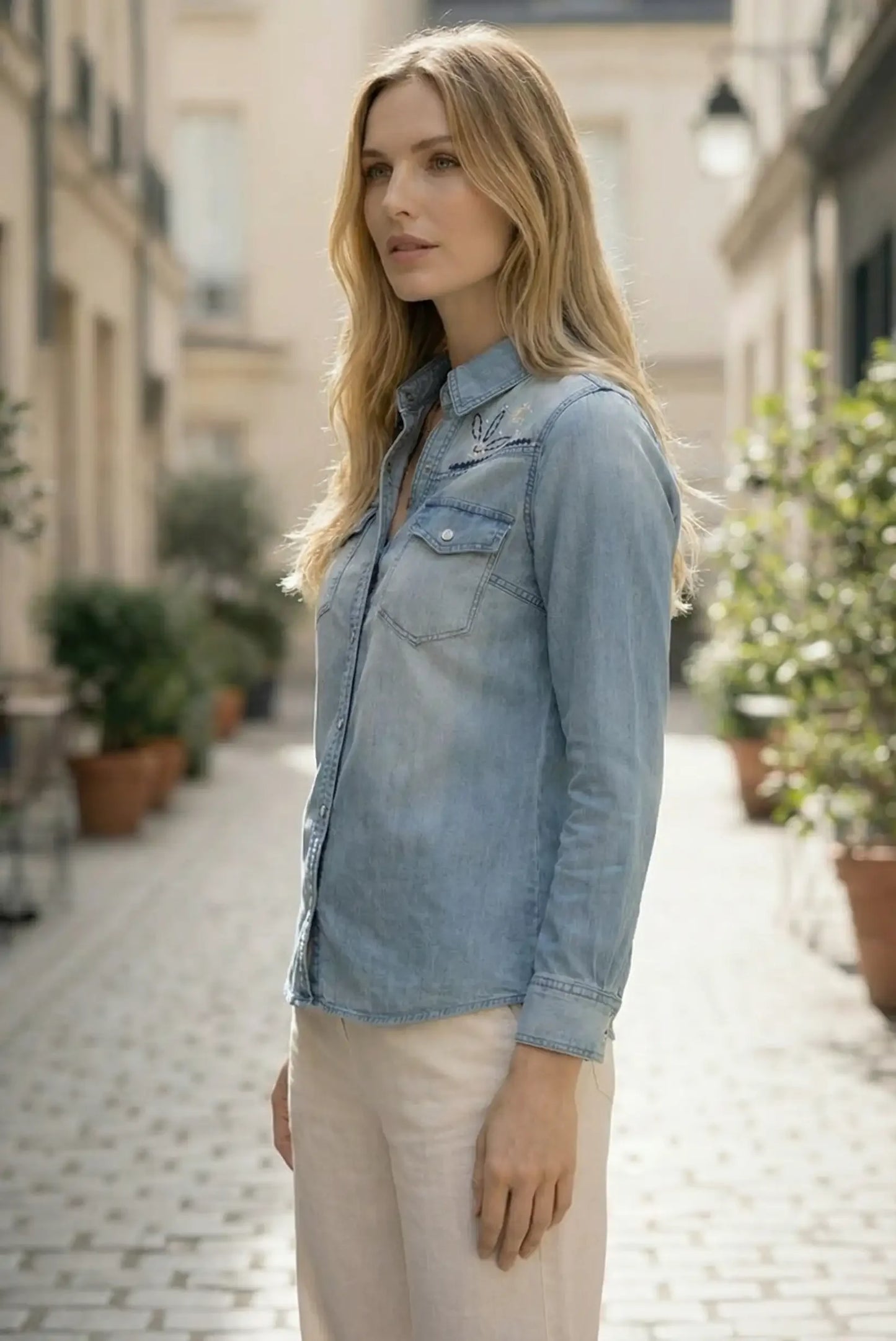Mujer con camisa vaquera azul de manga larga y bordado floral, estilo casual primaveral