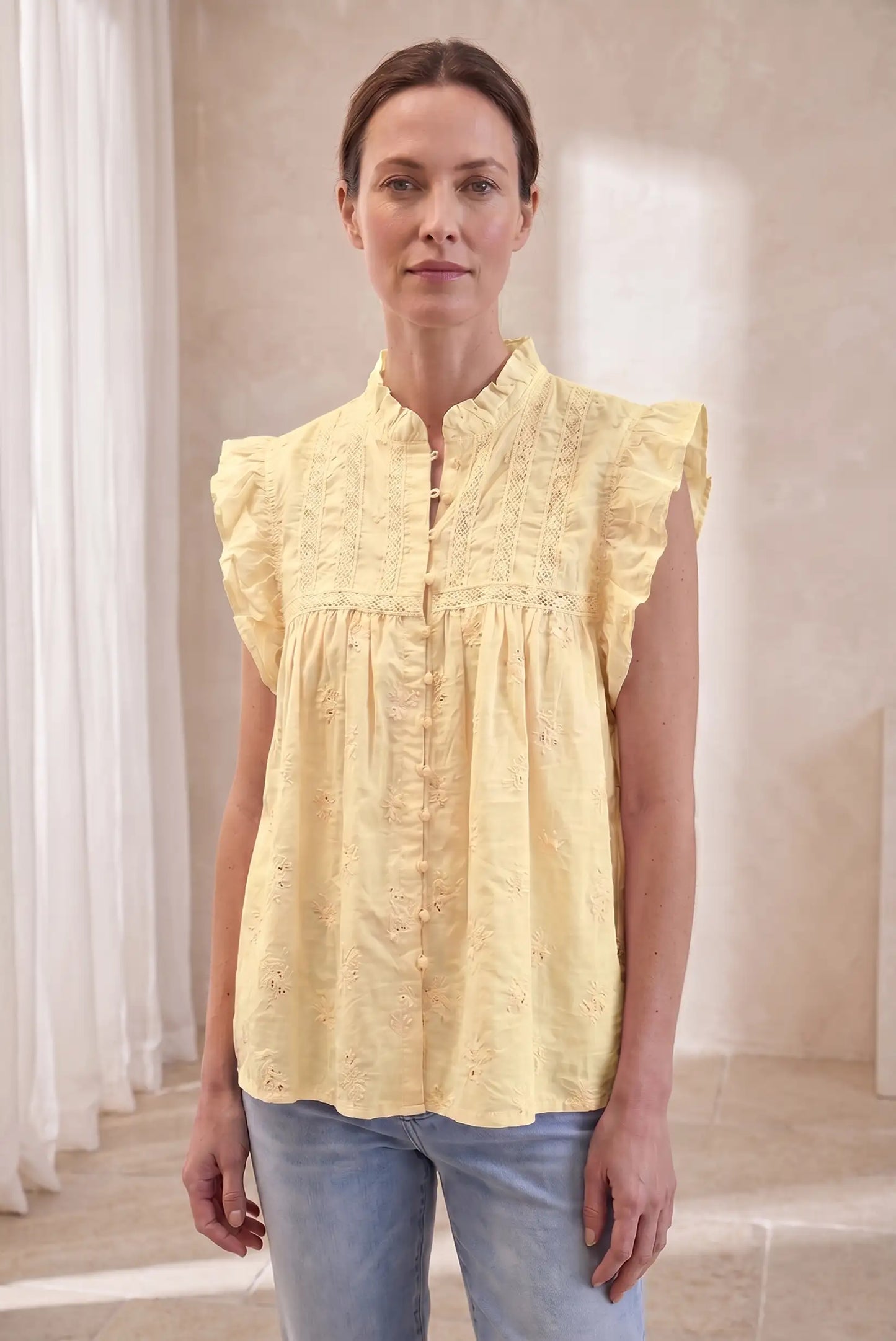 Camisa de mujer sin mangas amarillo pastel con volantes, estilo casual de verano.