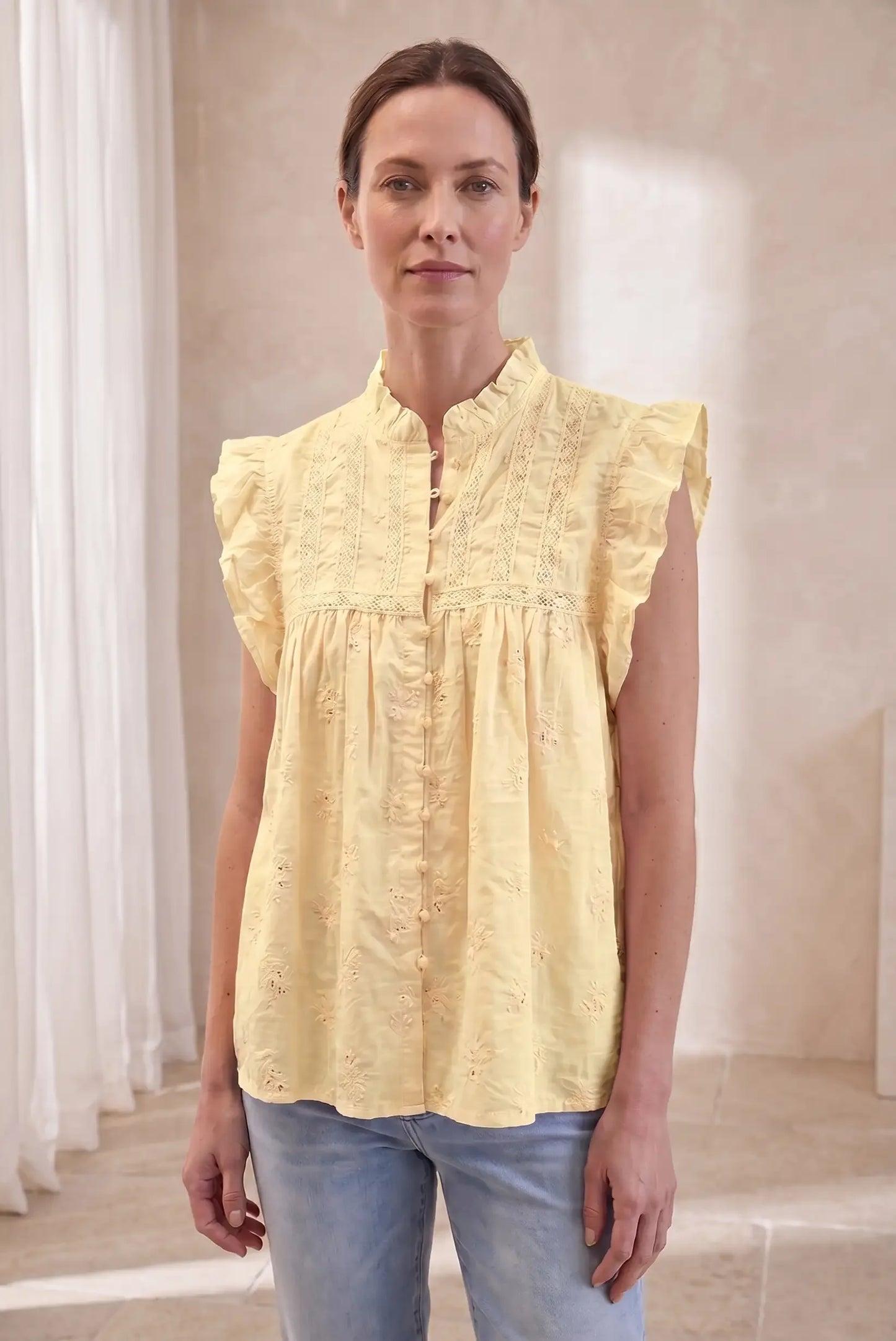 Camisa de mujer sin mangas amarillo pastel con volantes, estilo casual de verano.
