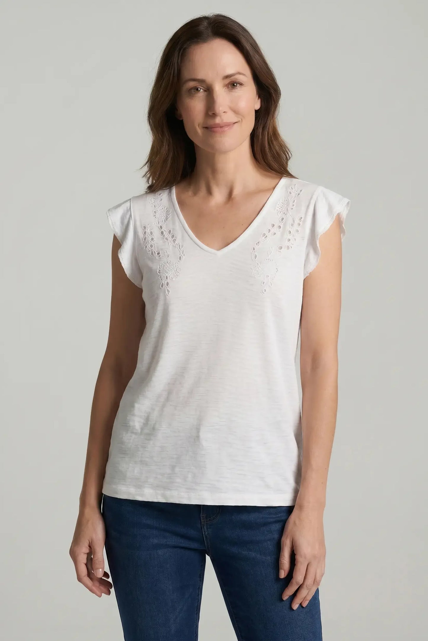 Mujer con camiseta blanca calada de manga corta y cuello en V, look casual de primavera