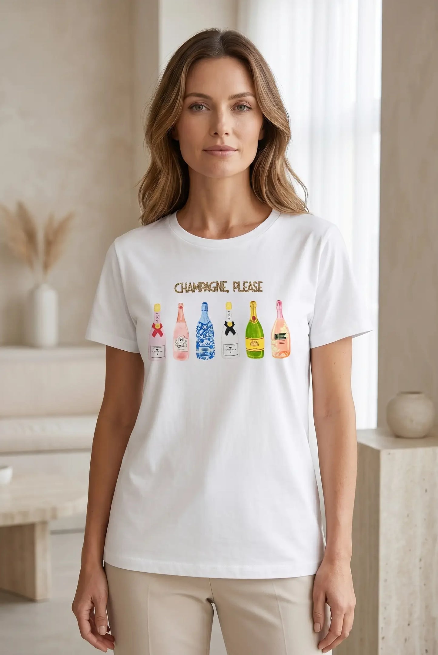 Mujer con camiseta blanca de manga corta estampada con botellas de champagne y texto 'Champagne, Please'.
