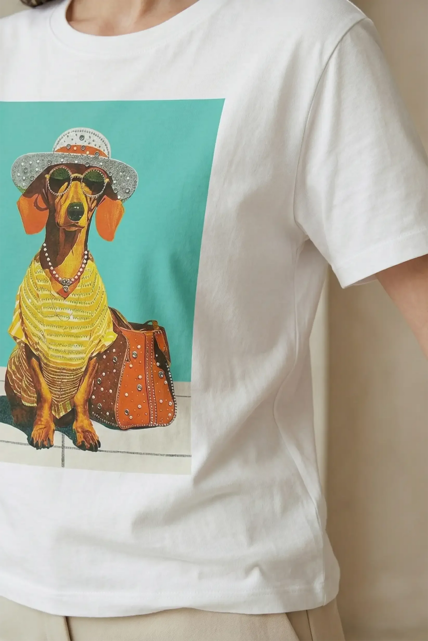 Camiseta blanca de mujer con estampado de perro salchicha vestido con gafas y sombrero.