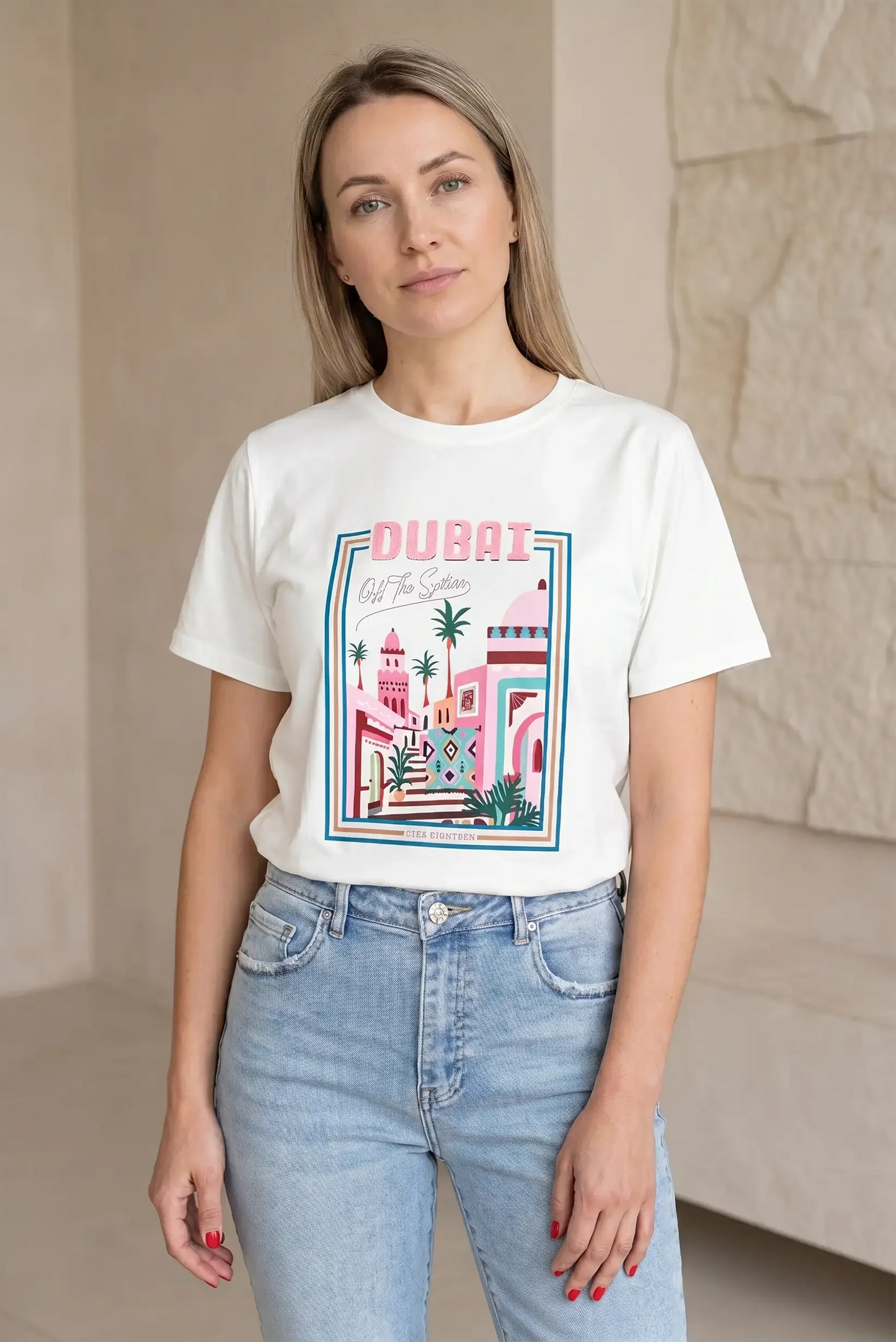 Mujer con camiseta blanca de manga corta con estampado colorido de Dubái y jeans claros