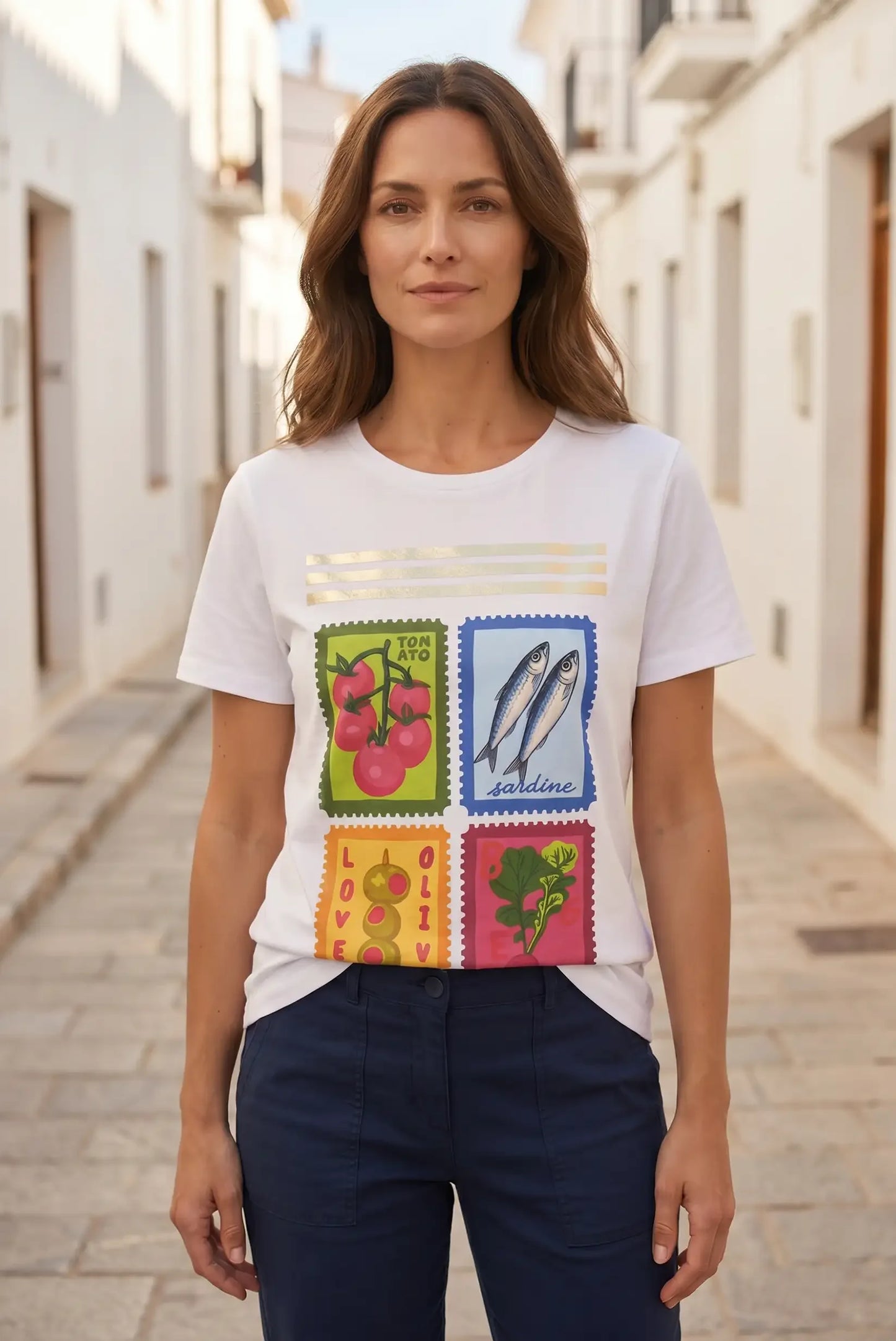 Camiseta blanca con estampado de sellos de tomate, sardinas, aceitunas y verduras, ideal para moda femenina.