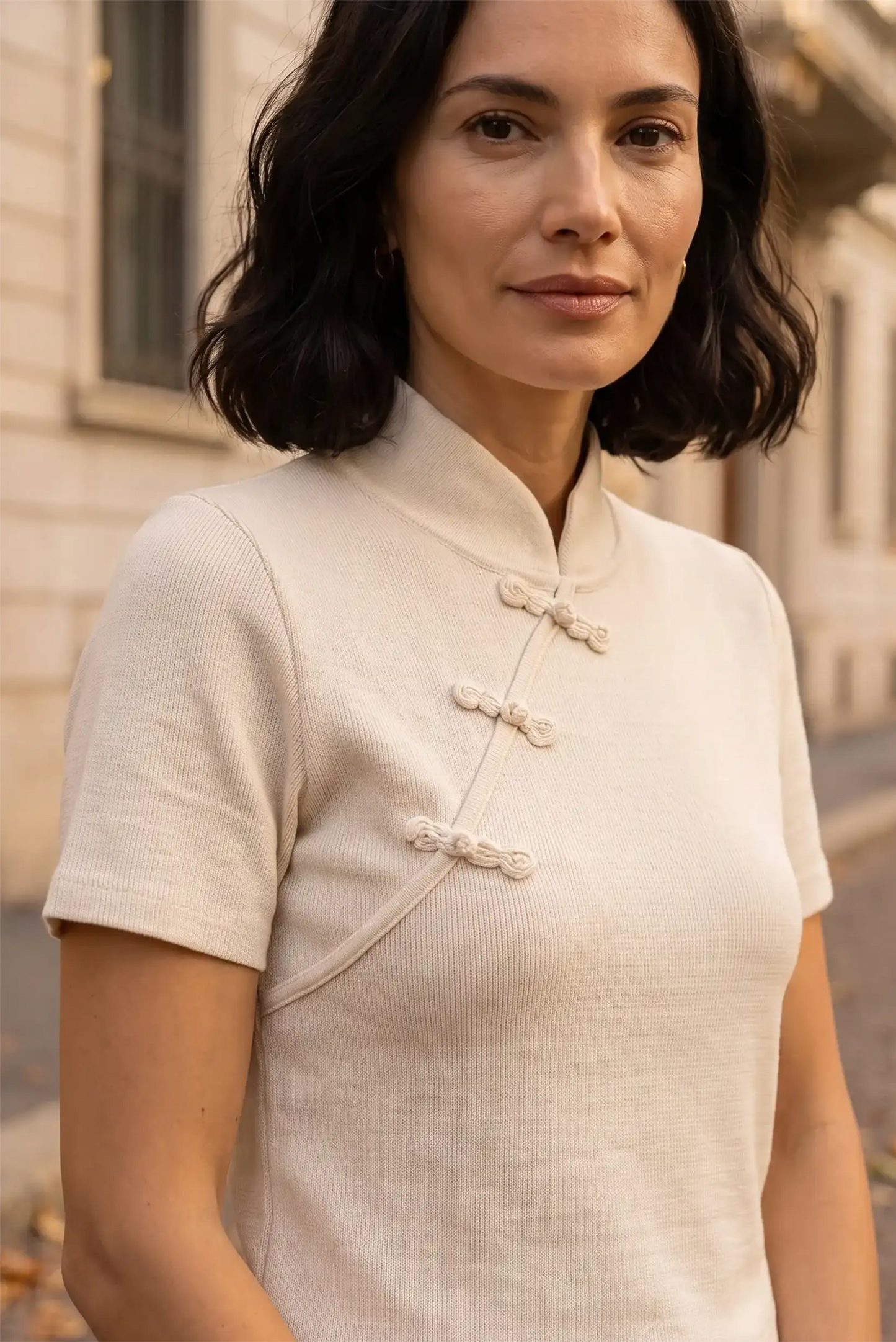 Mujer con camiseta blanca de manga corta y cierre de botones chinos tradicionales.