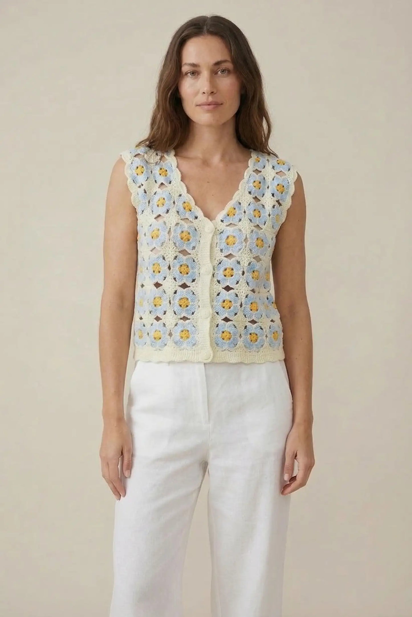 Mujer con chaleco de crochet azul claro y flores, look casual de primavera-verano