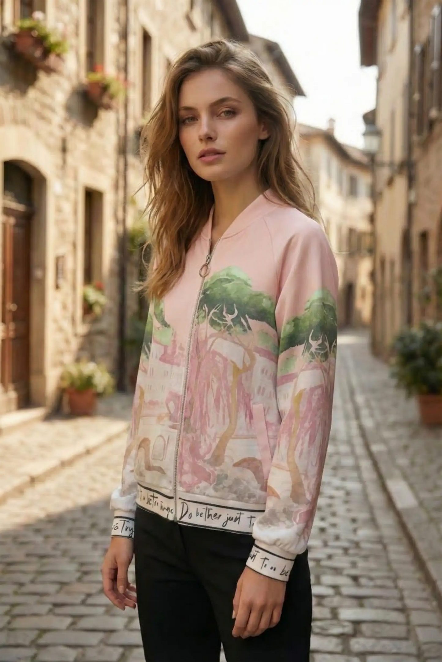 Mujer con chaqueta rosa estampada de CHICA del Sur en calle adoquinada, moda femenina casual.