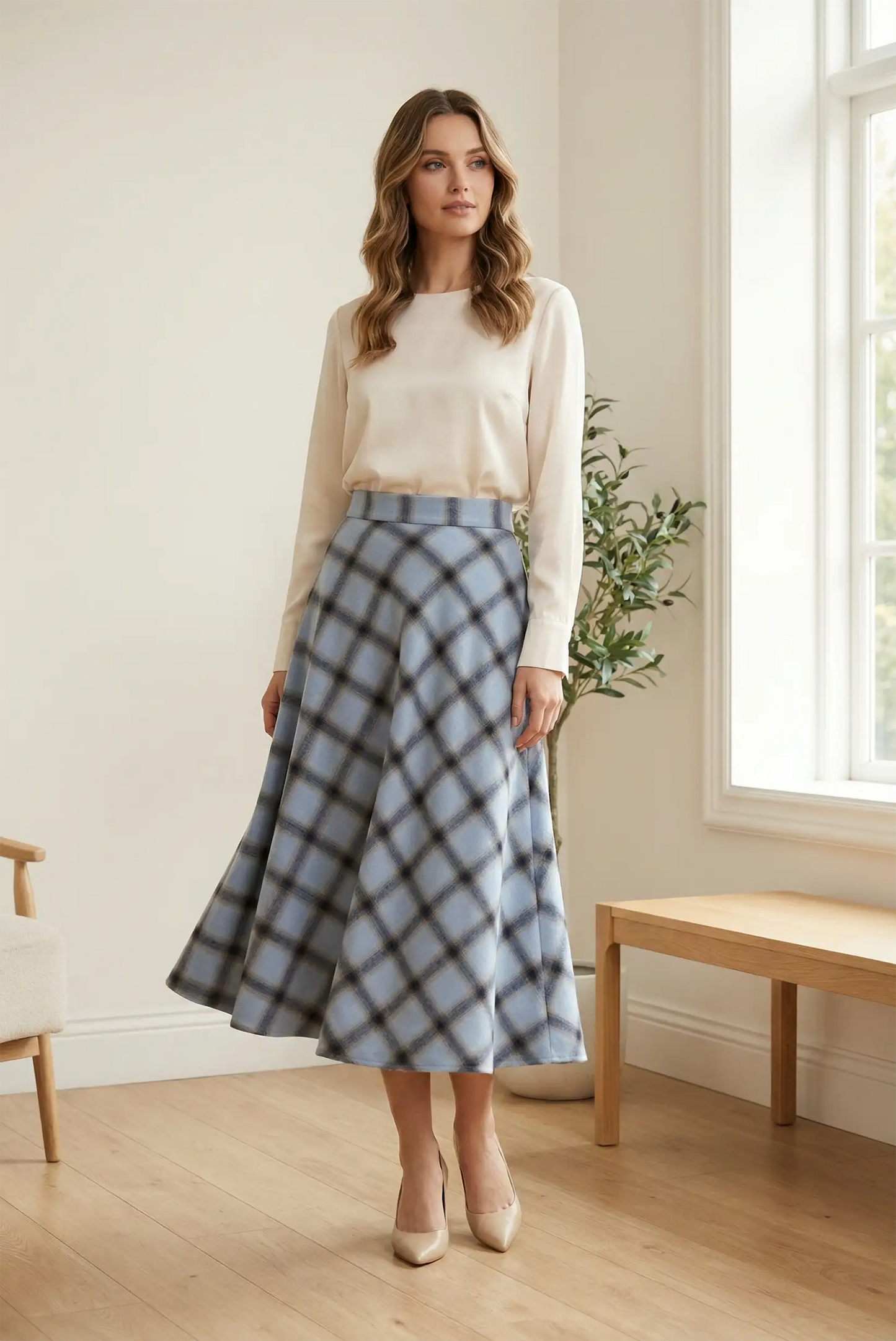 Mujer con falda larga azul de cuadros y blusa beige en interior luminoso, moda femenina CHICA del Sur