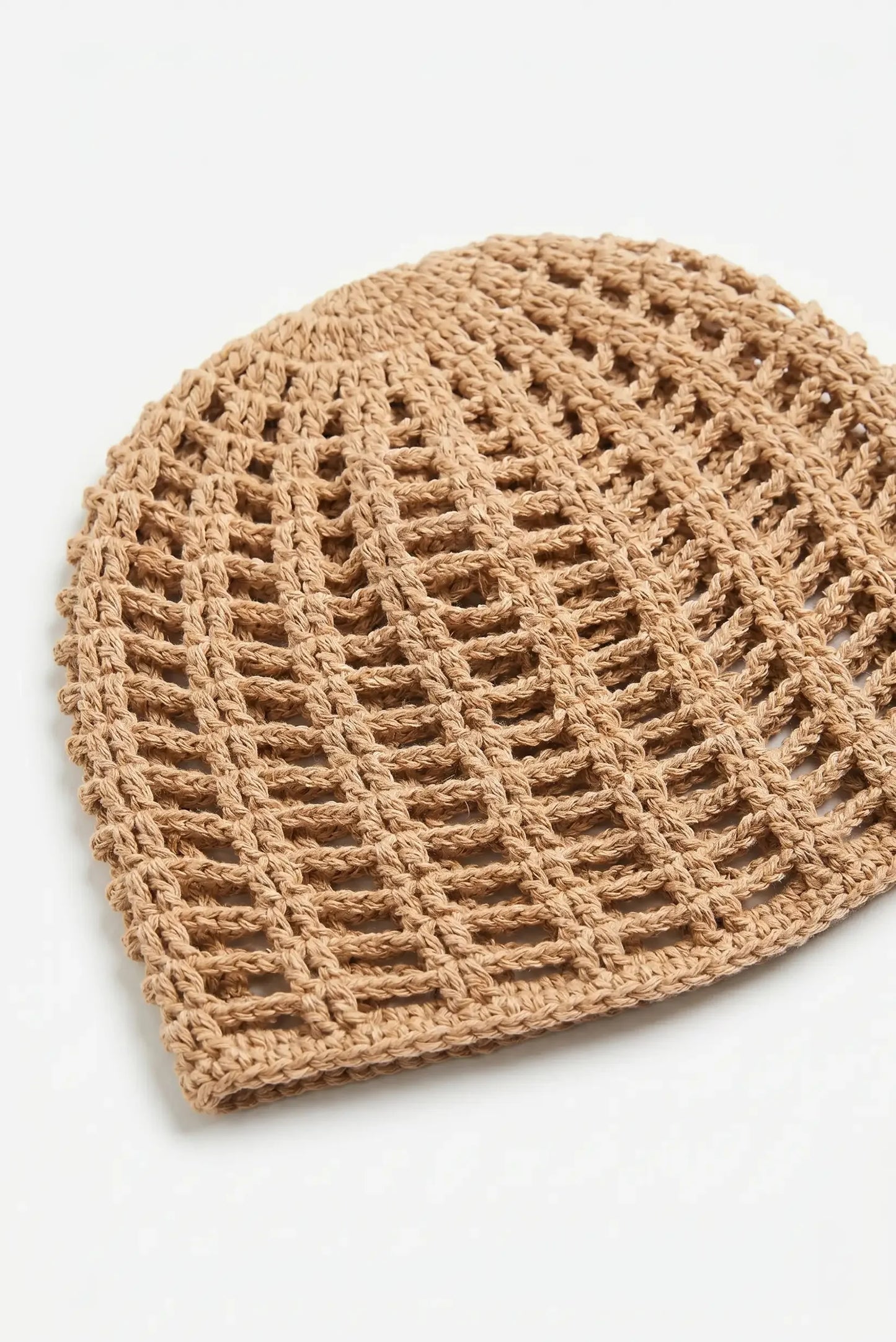 Gorro tejido en beige con patrón de malla, ideal para moda femenina y complementos