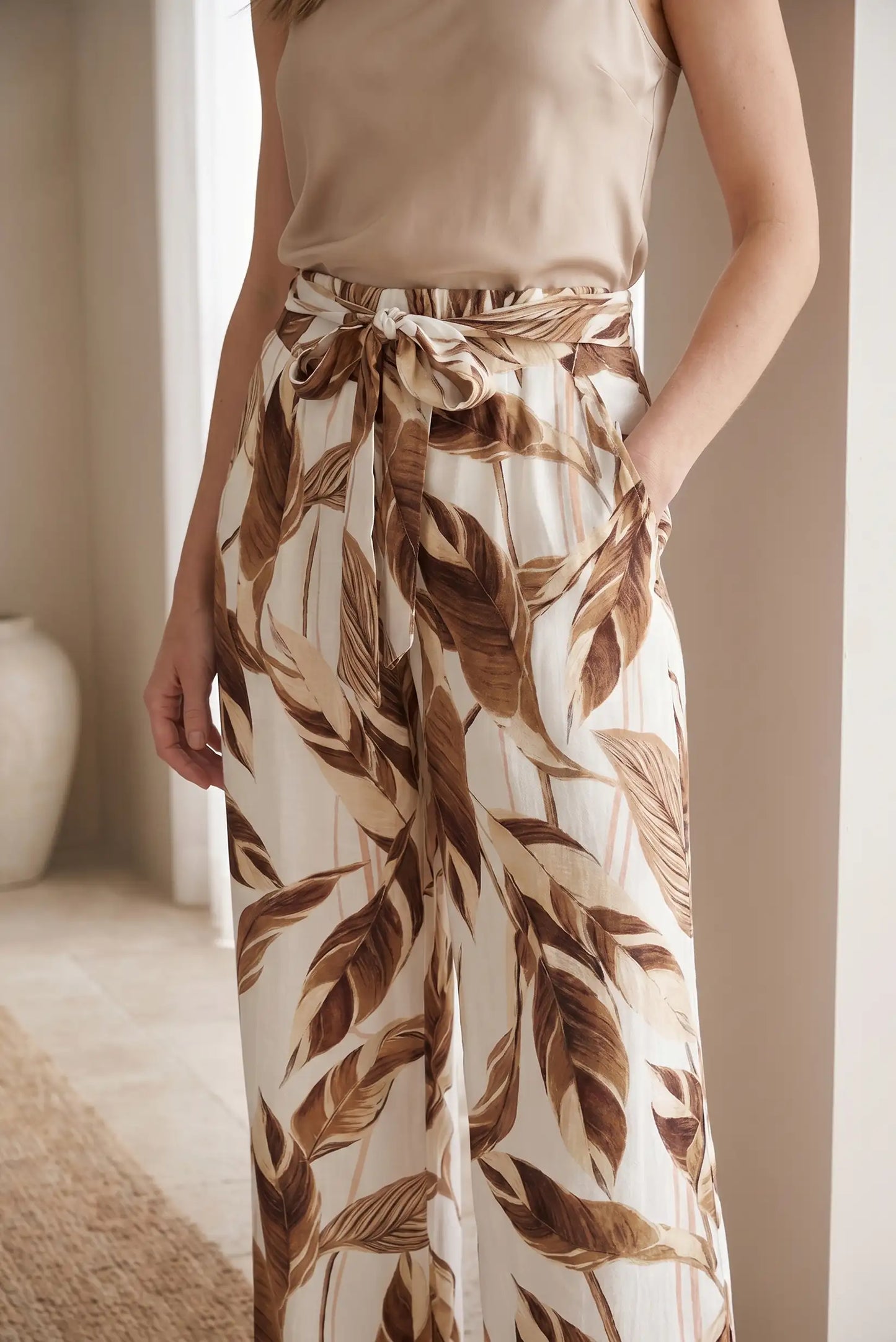 Pantalón largo fluido mujer con estampado de hojas en tonos ocre y marrón, lazo en cintura