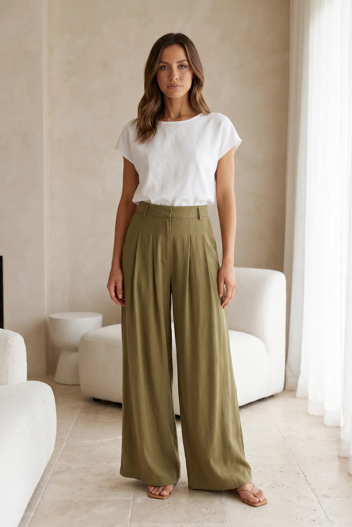 Mujer con pantalón fluido verde y camiseta blanca, moda casual femenina, interior elegante
