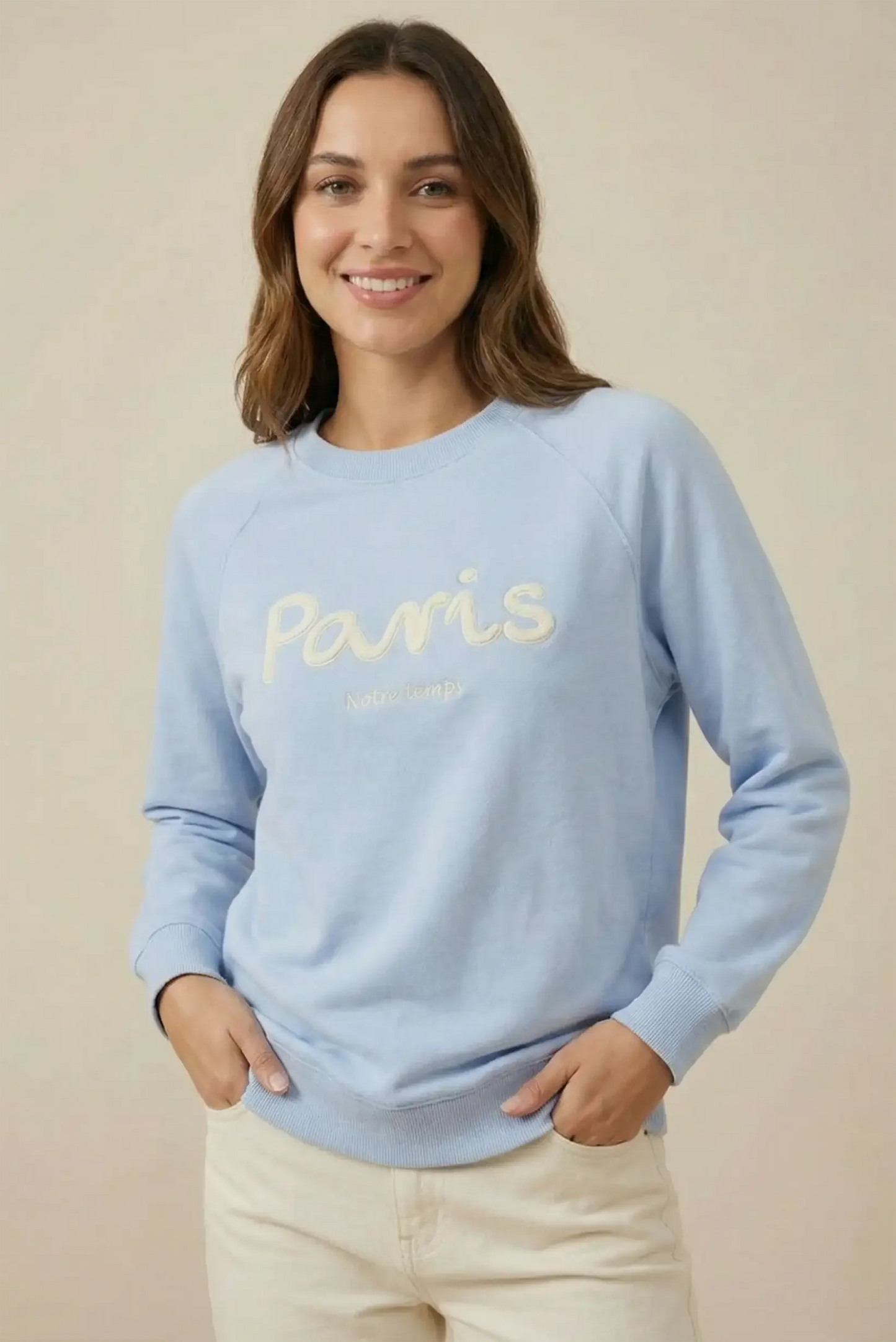 Mujer sonriente con sudadera azul pastel Paris, moda casual femenina CHICA del Sur