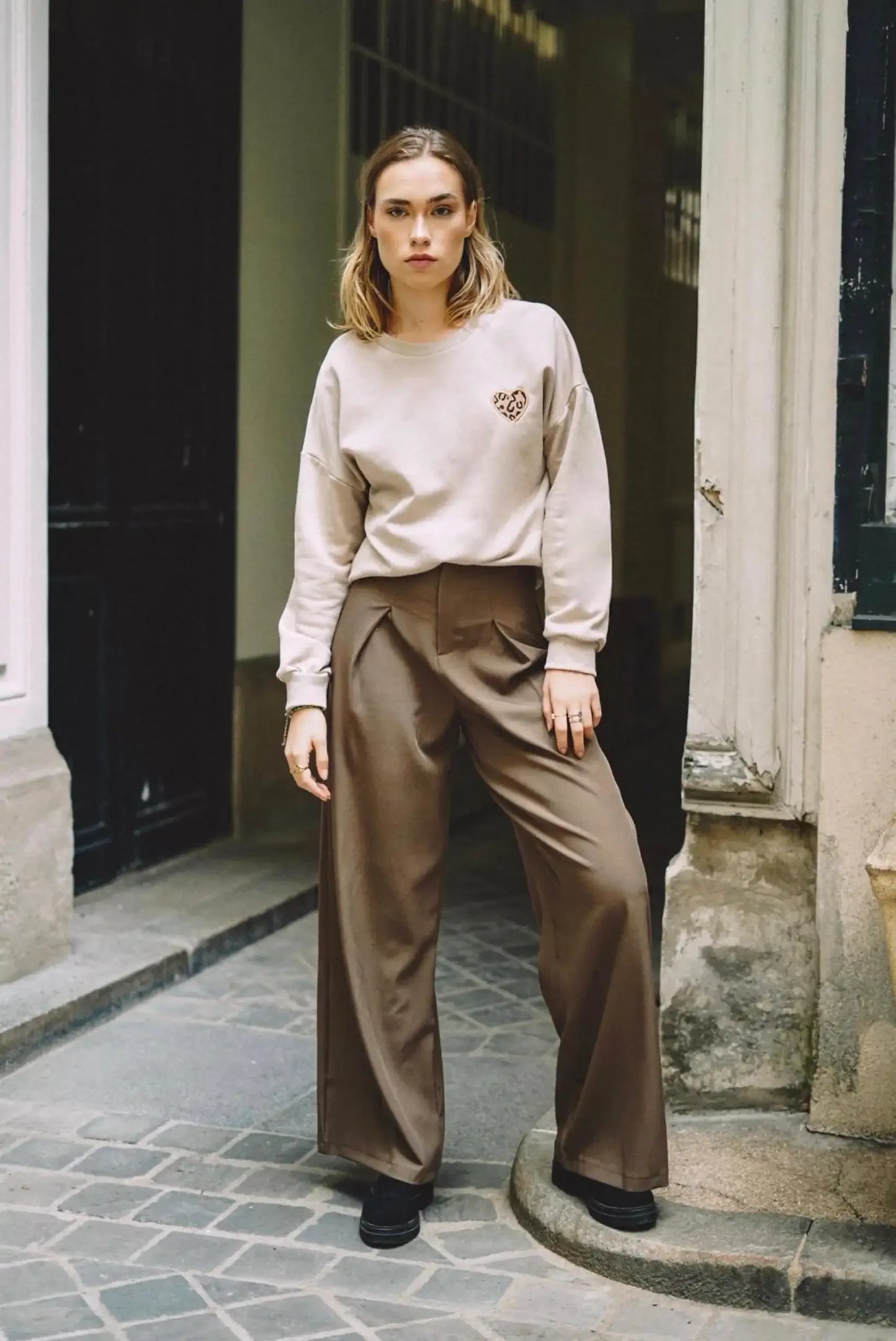 Mujer con sudadera beige con corazón animal print y pantalón marrón, moda CHICA del Sur.