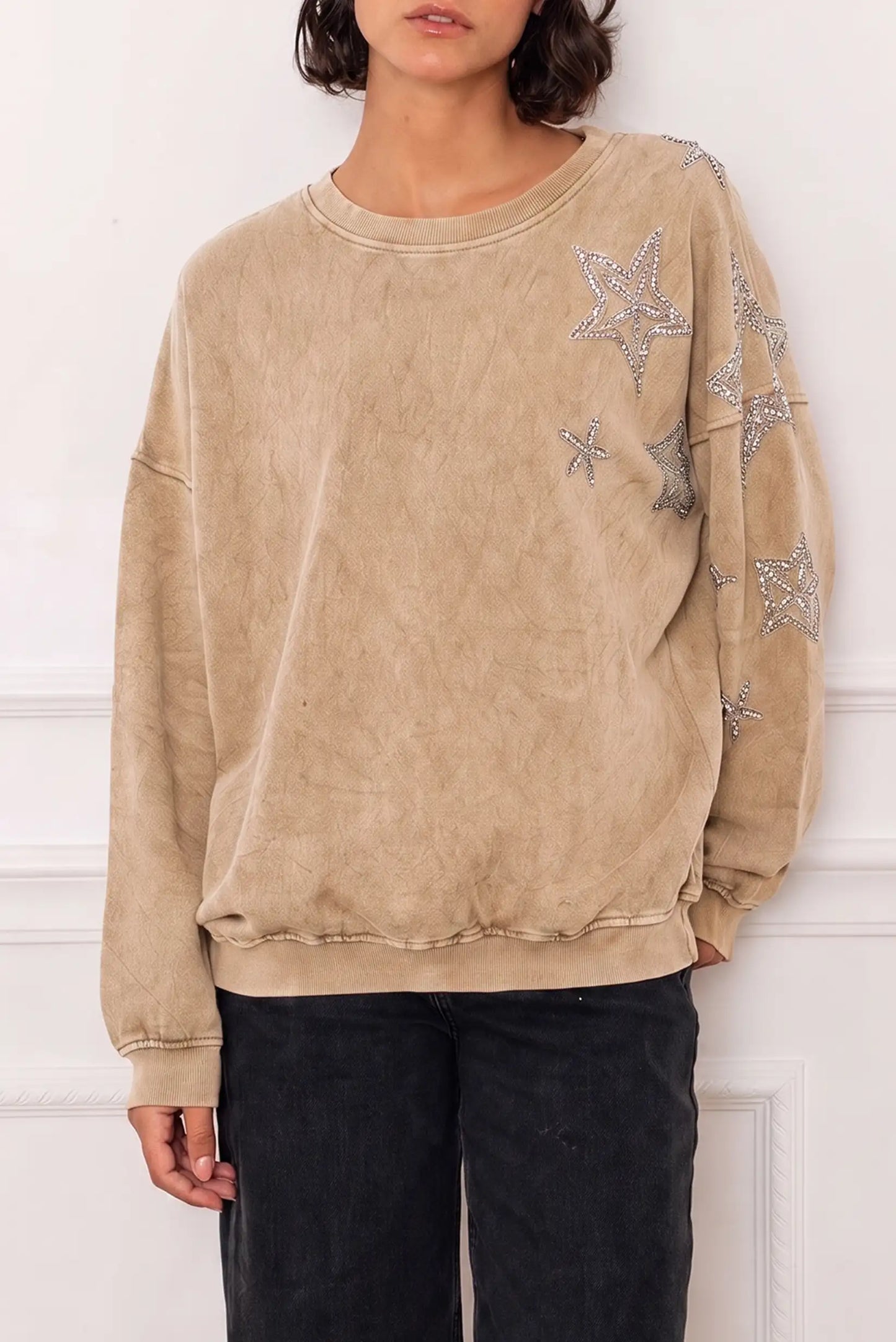 Sudadera beige lavada para mujer con estrellas brillantes decorativas y pantalones negros