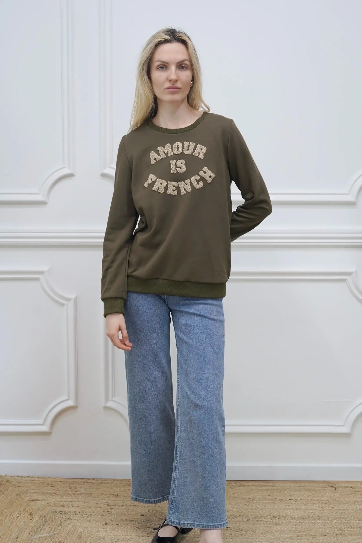 Mujer con sudadera verde kaki 'Amour is French' y jeans casual, moda CHICA del Sur