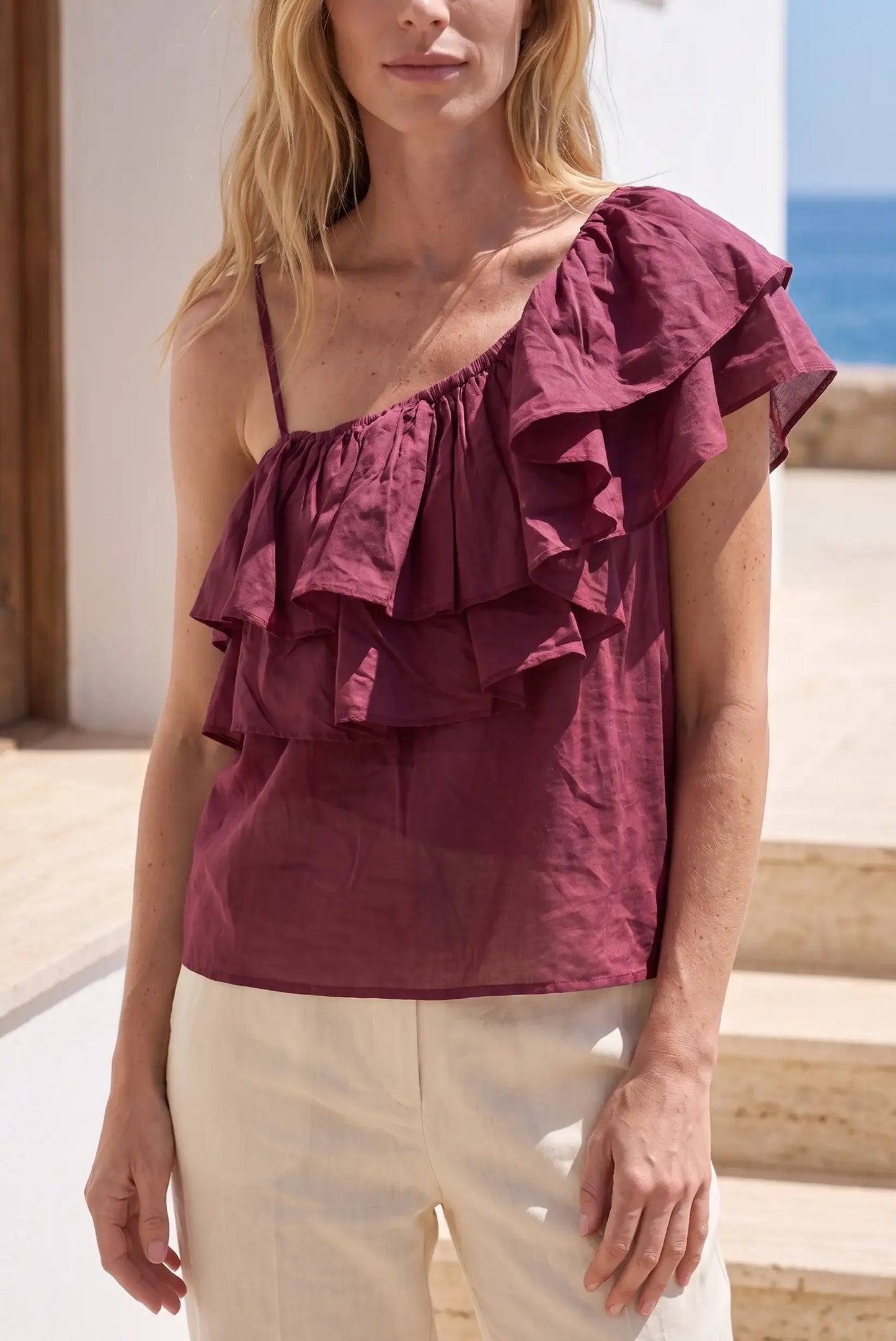 Blusa morada asimétrica con volantes y tirantes finos, ideal para verano y playa