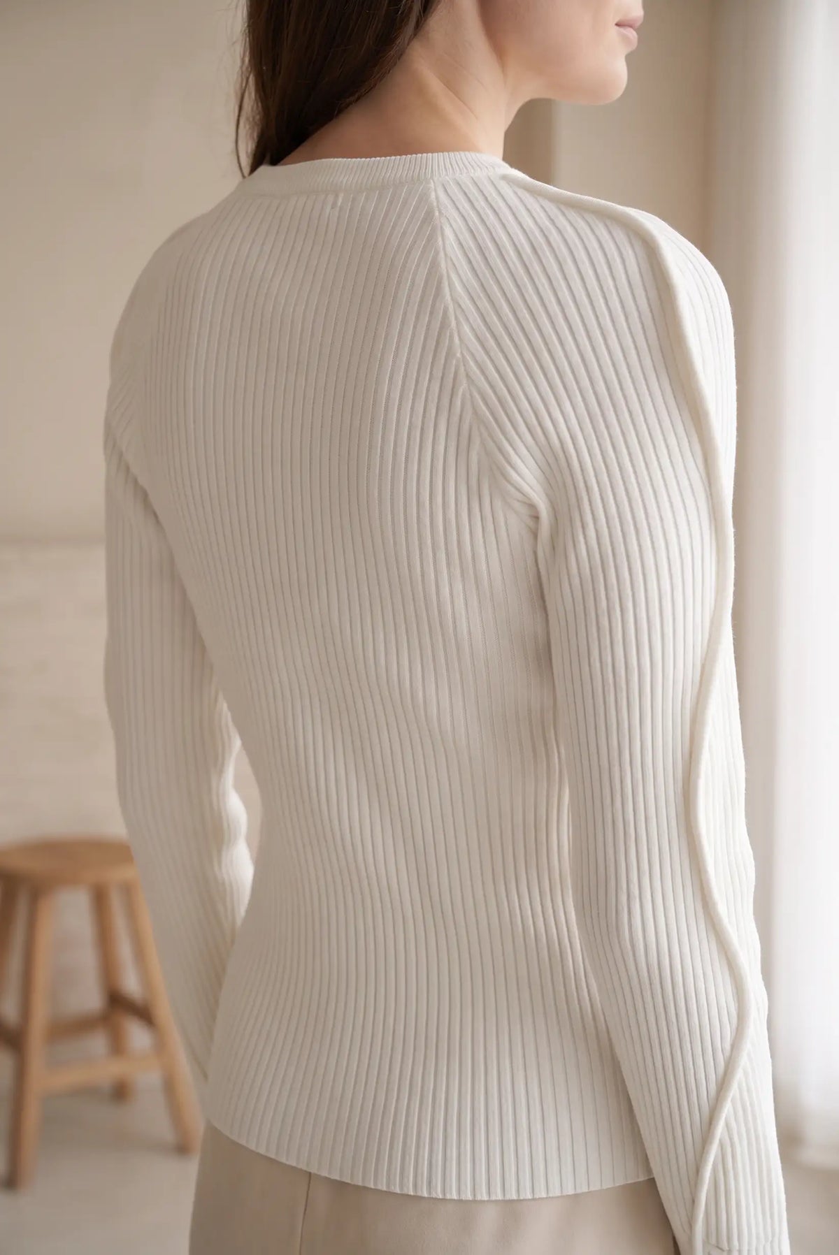 Detalle posterior de top blanco de punto canalé con manga abullonada de CHICA del Sur.