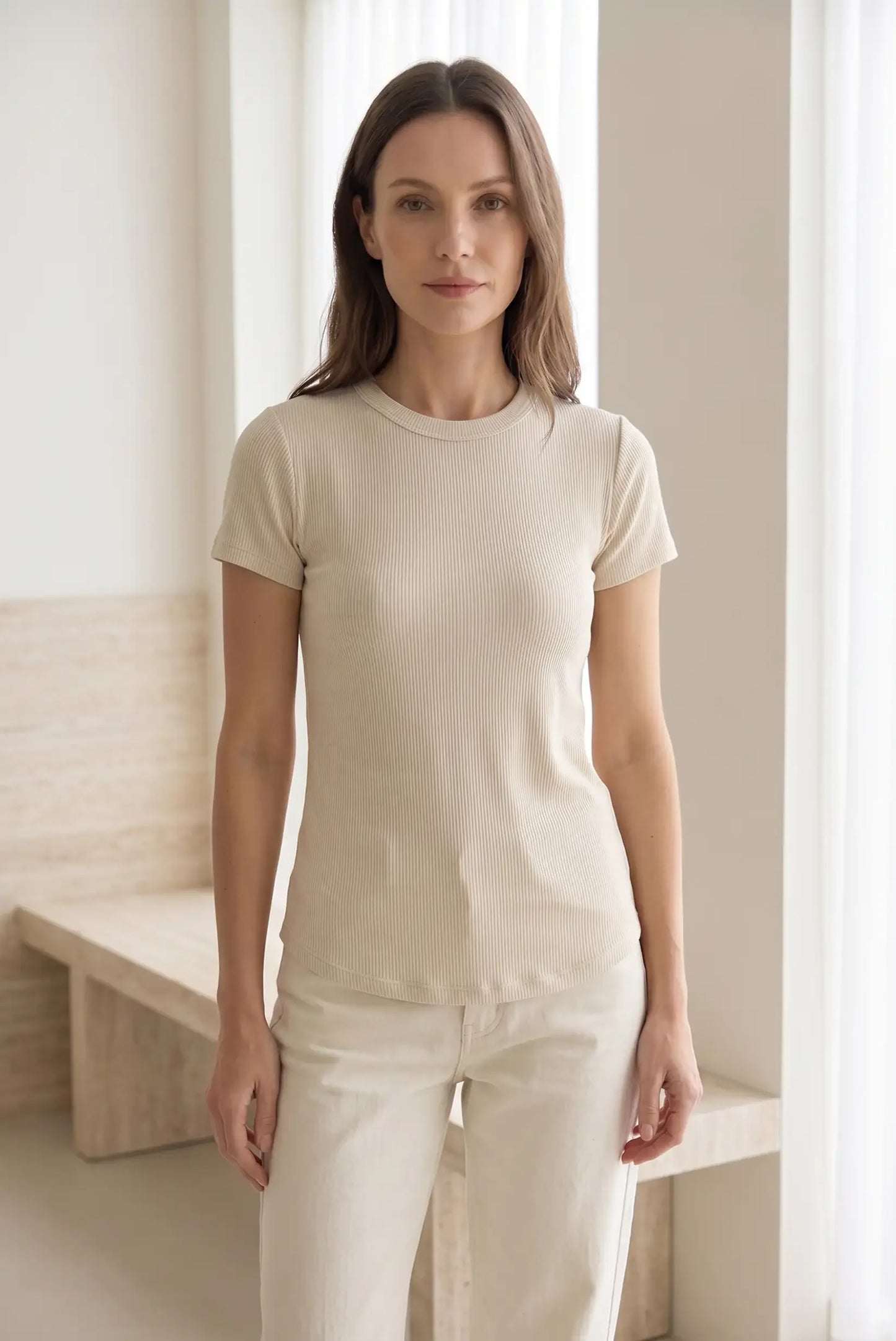 Mujer con camiseta beige de manga corta y pantalón claro, moda casual primavera