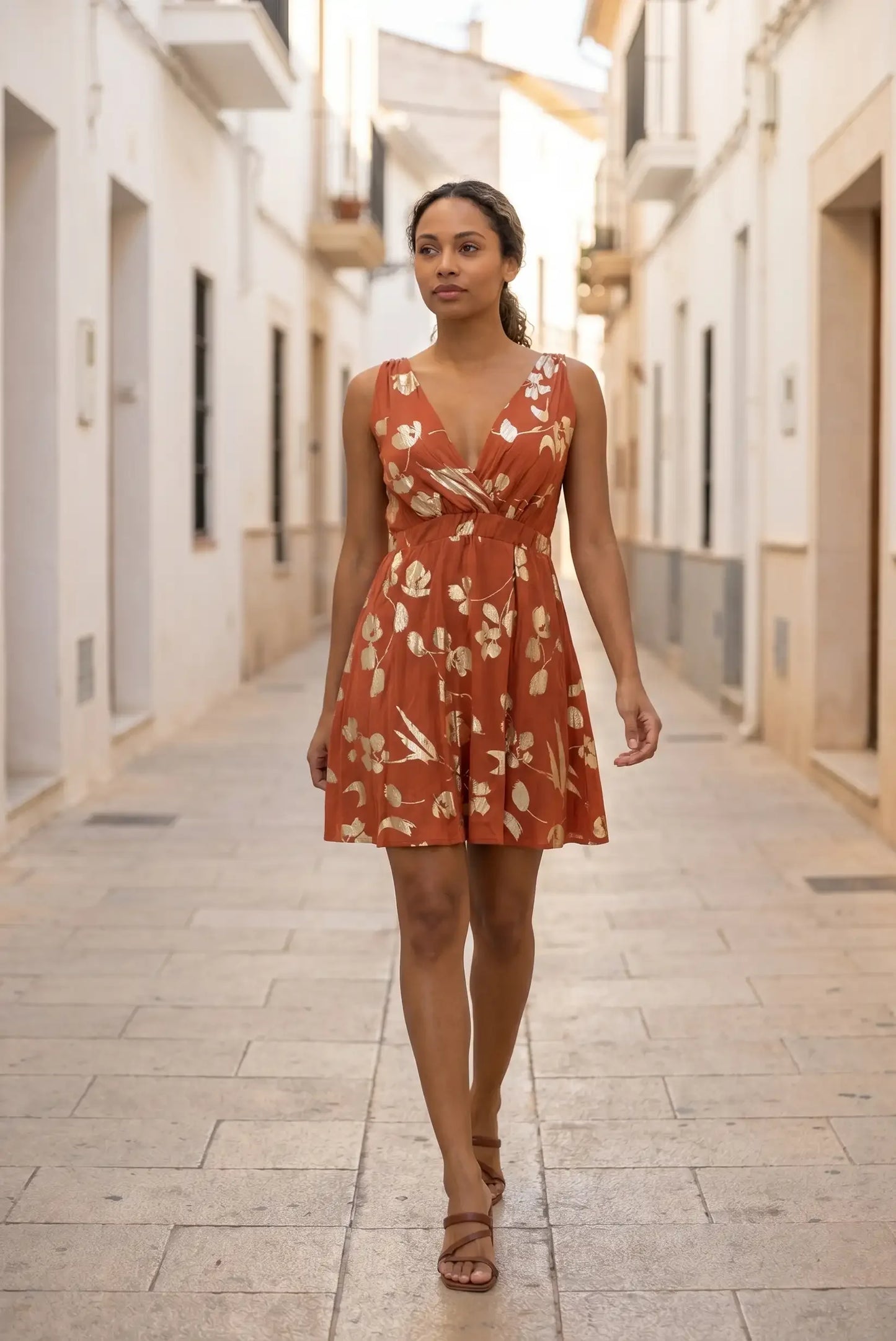 Vestido corto naranja con estampado floral dorado, ideal para verano y paseos urbanos