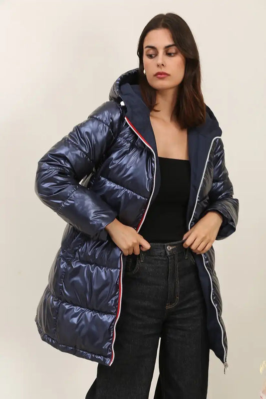 Mujer con abrigo largo azul reversible de invierno y capucha, fondo claro
