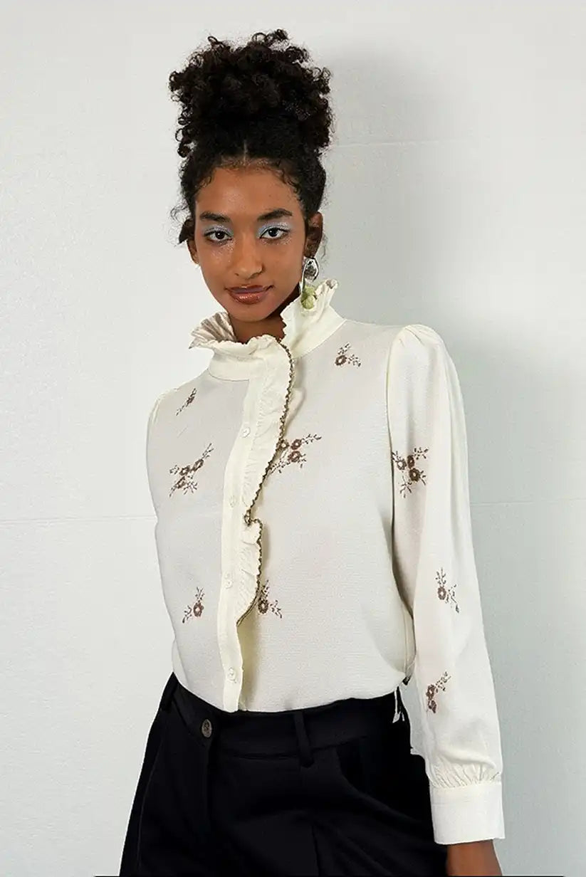 Camisa de mujer manga larga color crema con bordados marrones y volante en el cuello