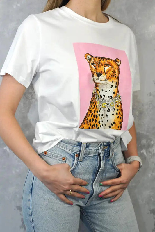 Camiseta blanca con estampado de leopardo y abalorios, combinada con jeans claros.