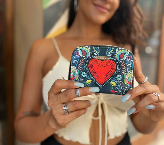 Mujer sosteniendo cartera Chula Tulum con corazón rojo y diseño floral colorido