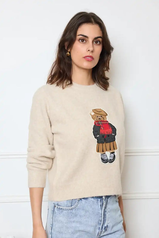 Mujer con jersey beige de otoño con dibujo de oso de peluche, jeans claros