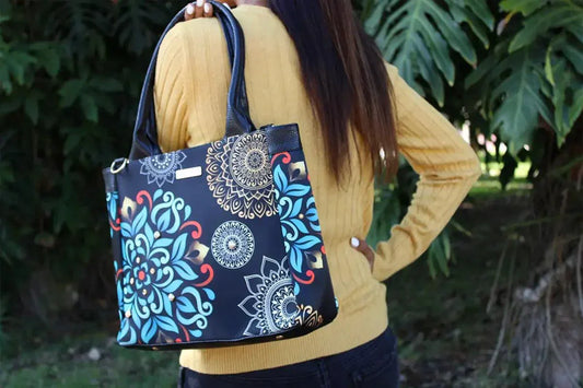 Mujer con bolso grande de mandala azul y dorado, look otoño invierno, exterior