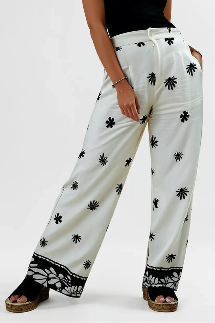 Pantalón largo fluido mujer beige con estampado floral negro, moda verano