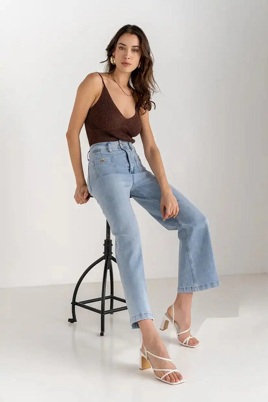 Mujer con jeans celestes de tiro alto y bolsillo delantero, top marrón, primavera 2025