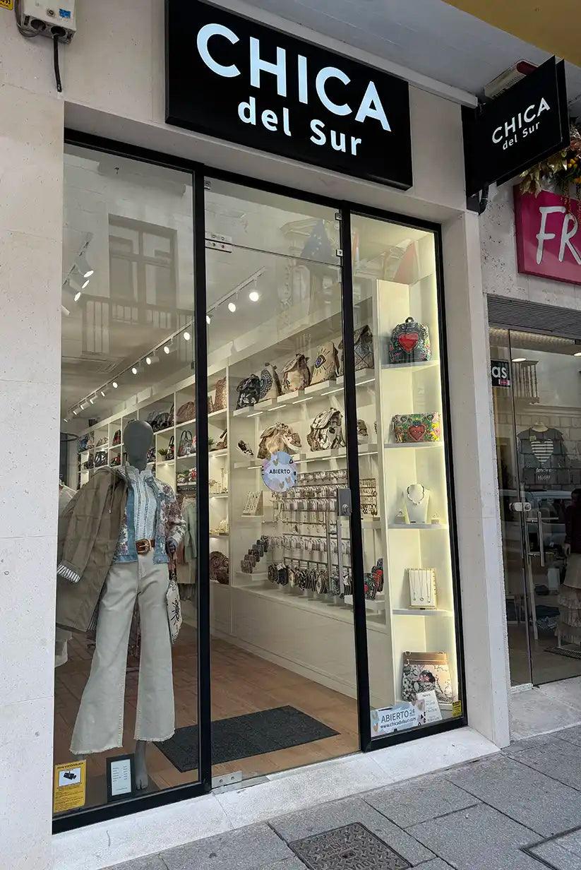Fachada de tienda boho CHICA del Sur con maniquí, bolsos y bisutería en escaparate