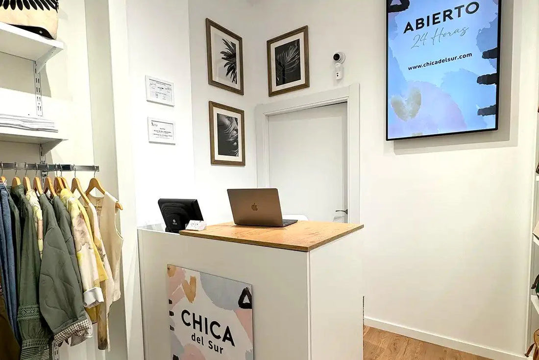 Tienda de moda casual para mujer en España, mostrador moderno, ropa en perchas y letrero digital