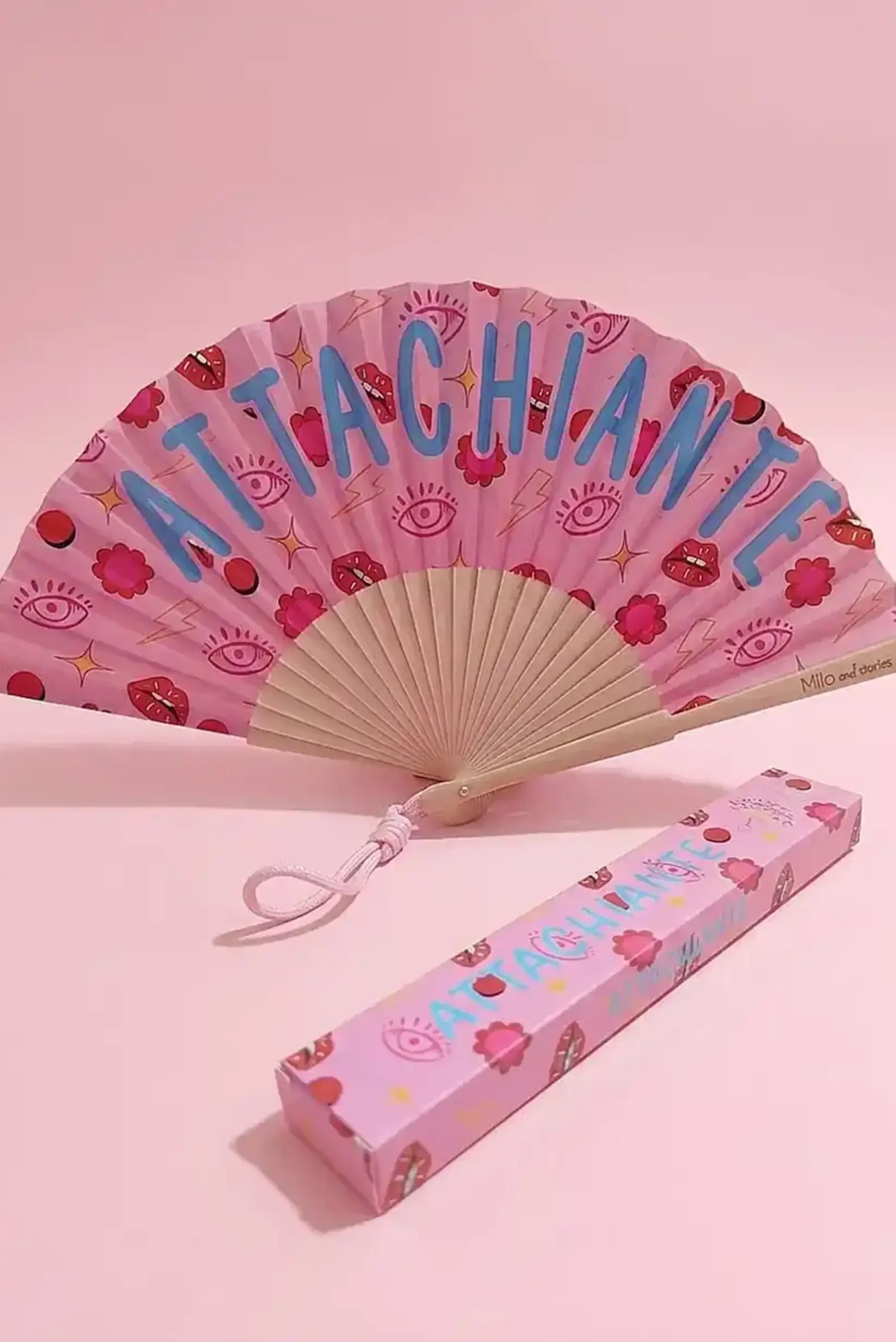 Abanico rosa con diseño 'ATTACHIANTE', ojos, labios y flores, ideal como complemento de moda femenina casual