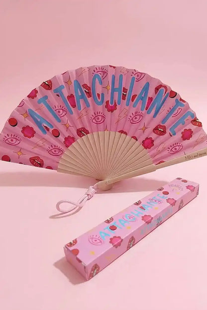 Abanico rosa con diseño 'ATTACHIANTE', ojos, labios y flores, ideal como complemento de moda femenina casual