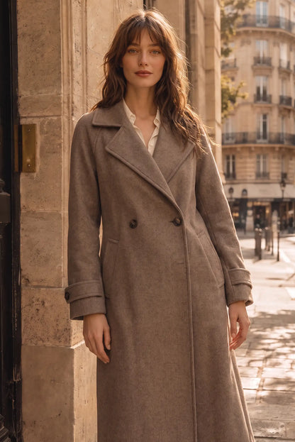 Mujer joven vistiendo un abrigo largo de lana color topo en una calle de París.
