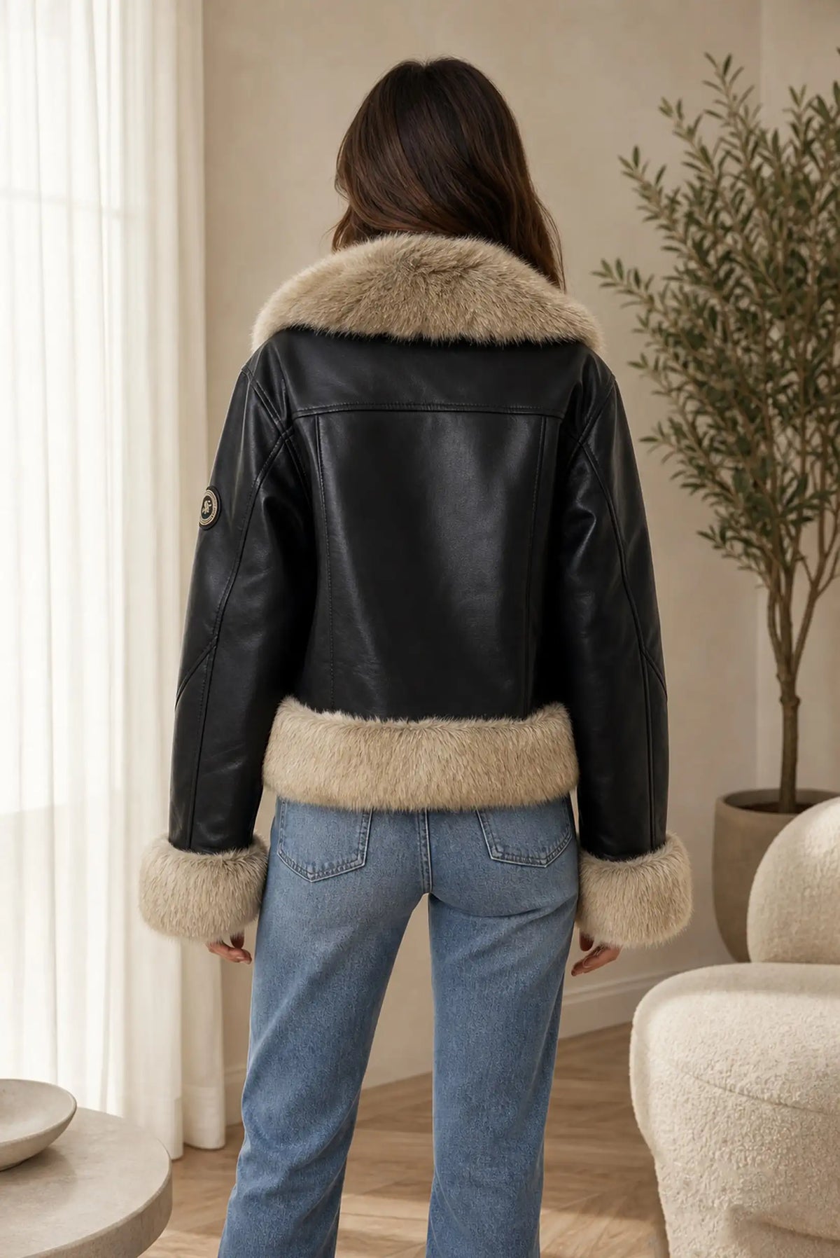 Vista trasera de mujer con cazadora de efecto piel negra y pelo sintético beige de CHICA del Sur
