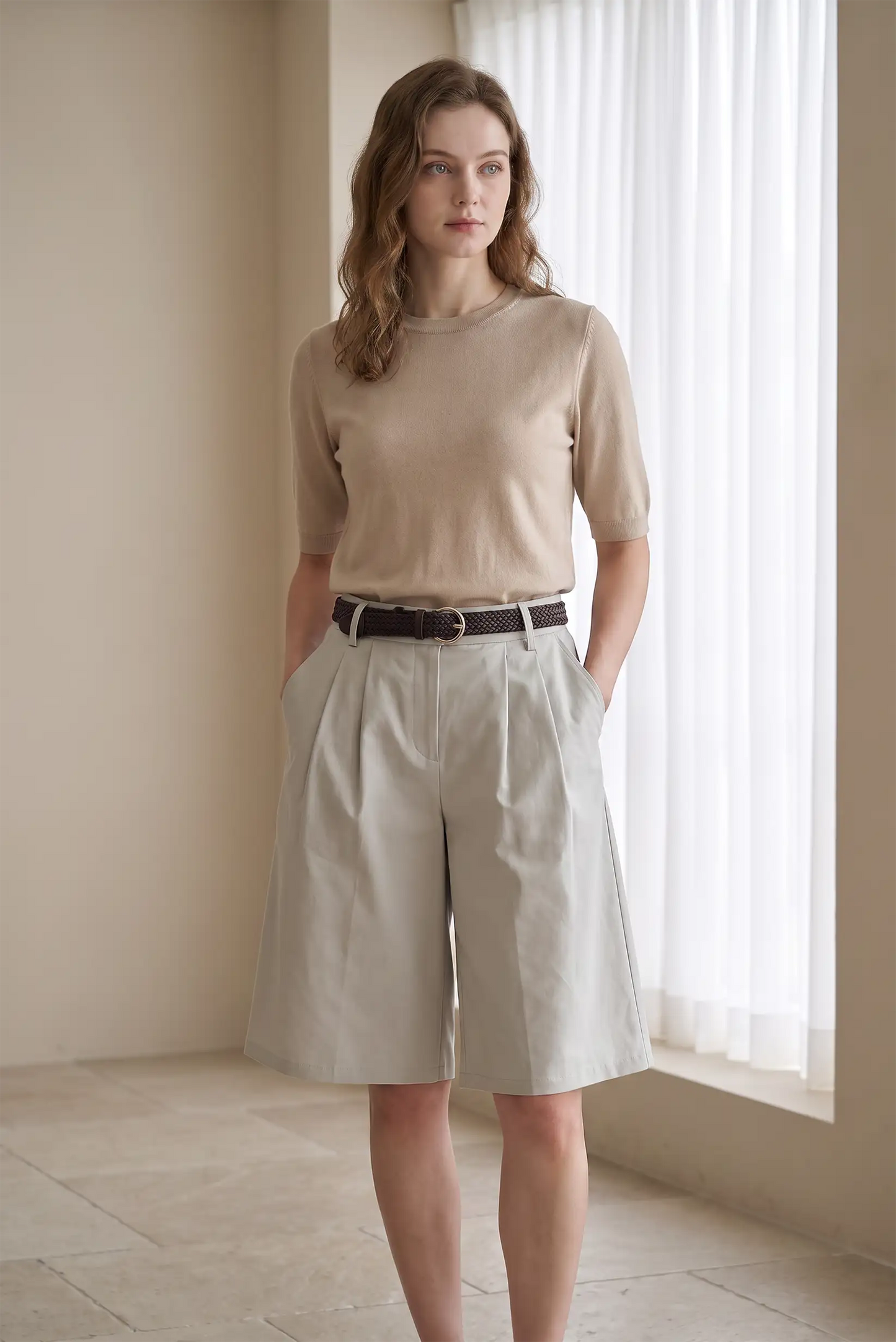 Mujer con camiseta beige de manga corta y bermudas beige de talle alto con cinturón marrón